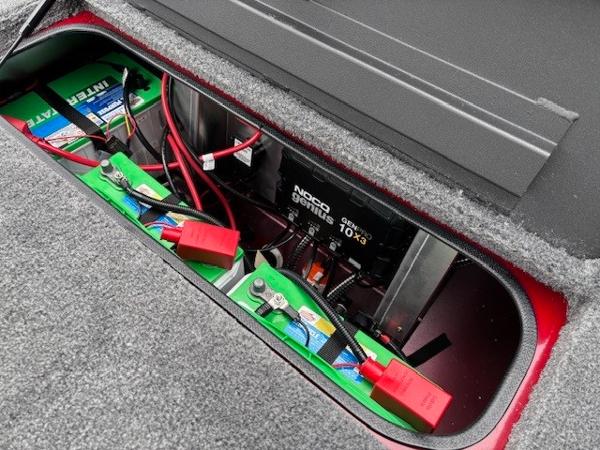 Battery compartment of 2025 Tracker Savage 215 with wiring and NOCO Genius charger.