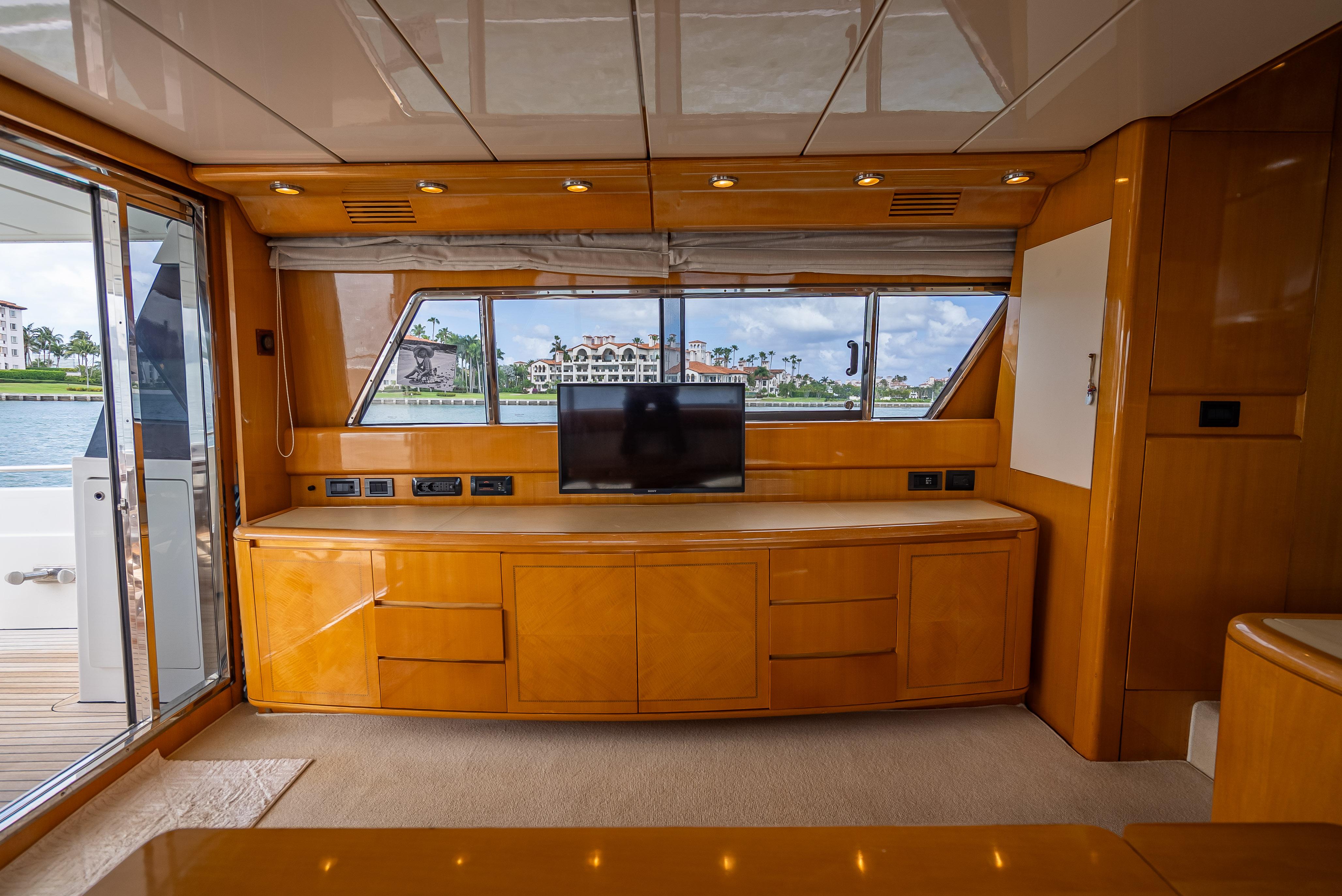Luxurious interior of 1995 Sanlorenzo 62 yacht with wood cabinetry and large windows.