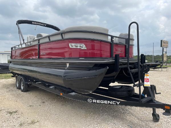 2023 Regency 250DL3 pontoon boat on trailer, red and black design, parked outdoors.