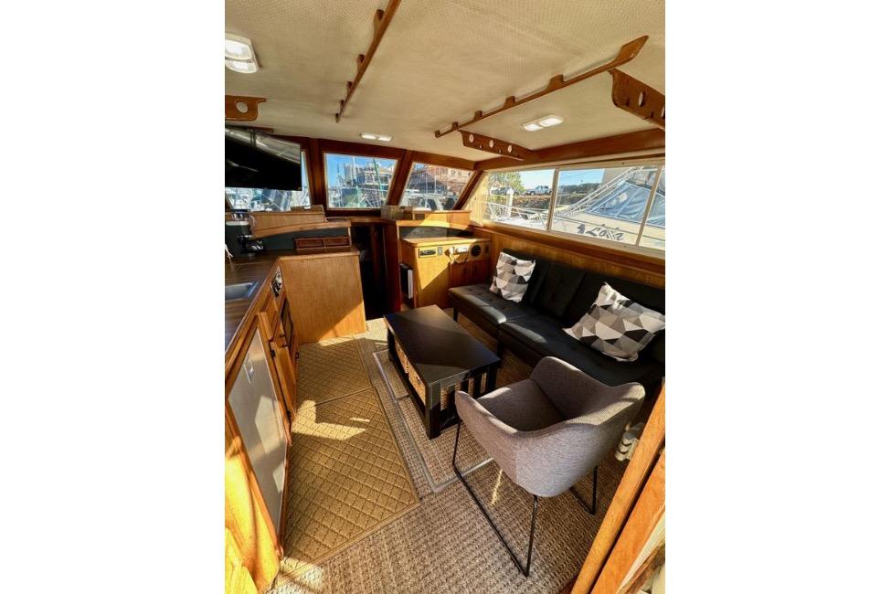 Interior of a 1985 Egg Harbor 33 Sedan yacht with cozy seating and wooden accents.