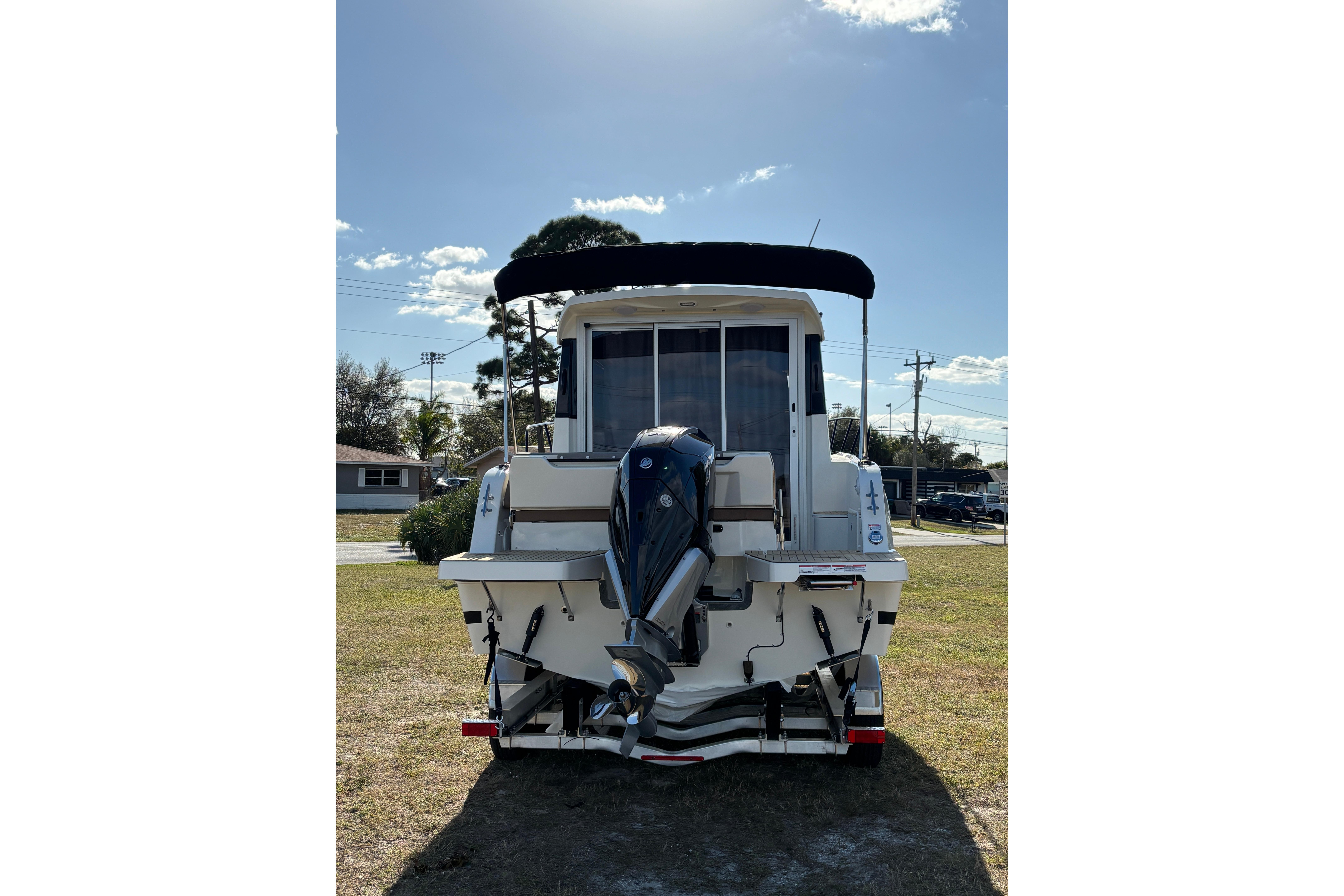 2026 Trophy T 25 Explorer boat with outboard motor, parked on grass under clear sky.