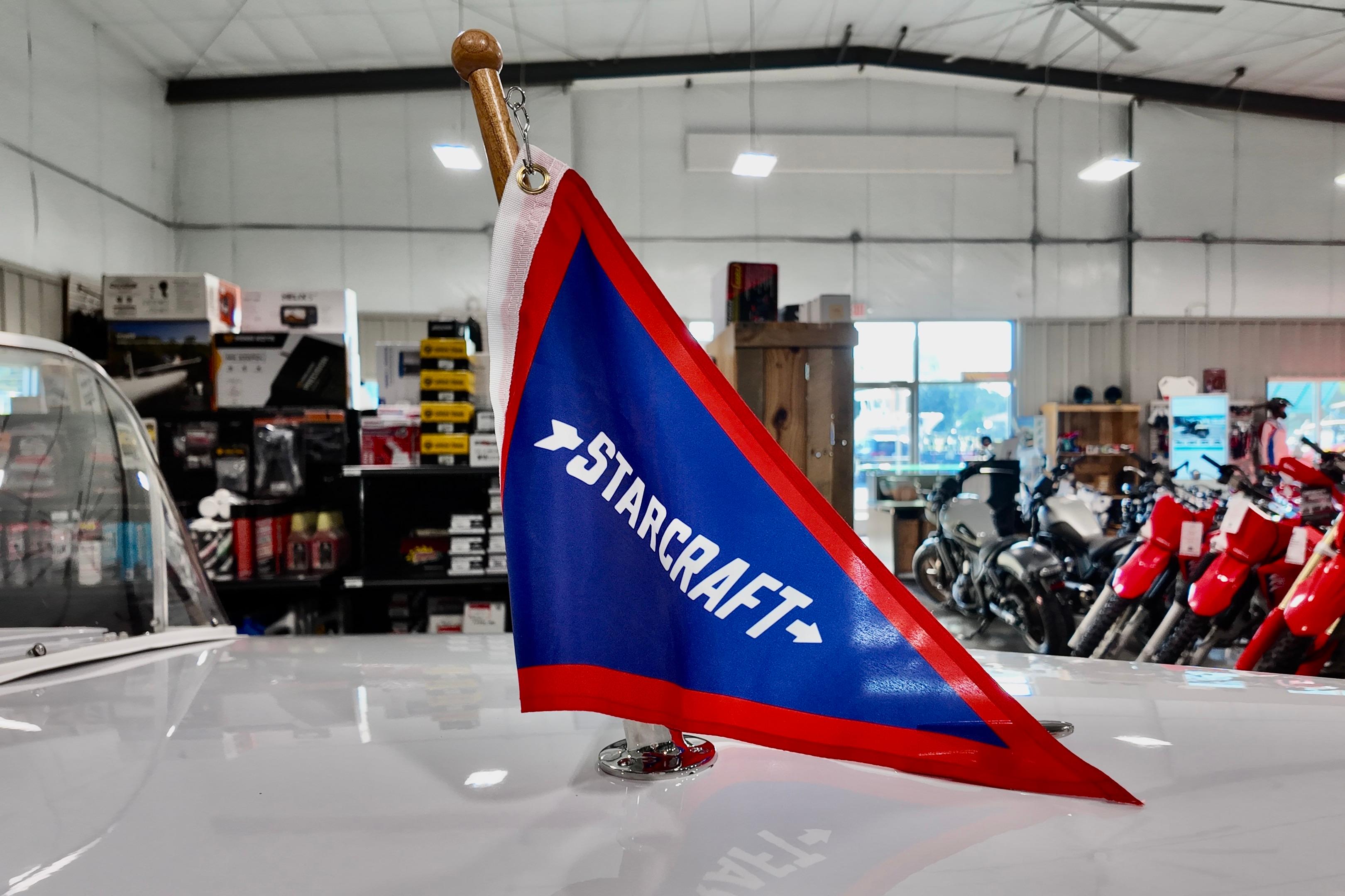 Red and blue Starcraft flag on 2026 Starcraft 57 Ski Champ boat in showroom.
