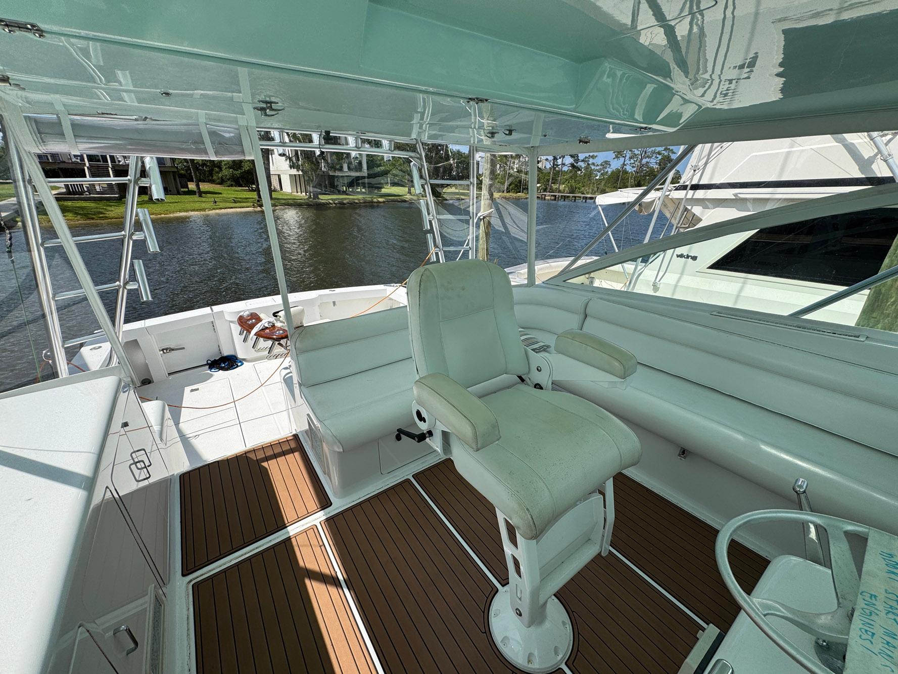 1999 Cabo 45 Express yacht interior with helm seat and spacious deck.