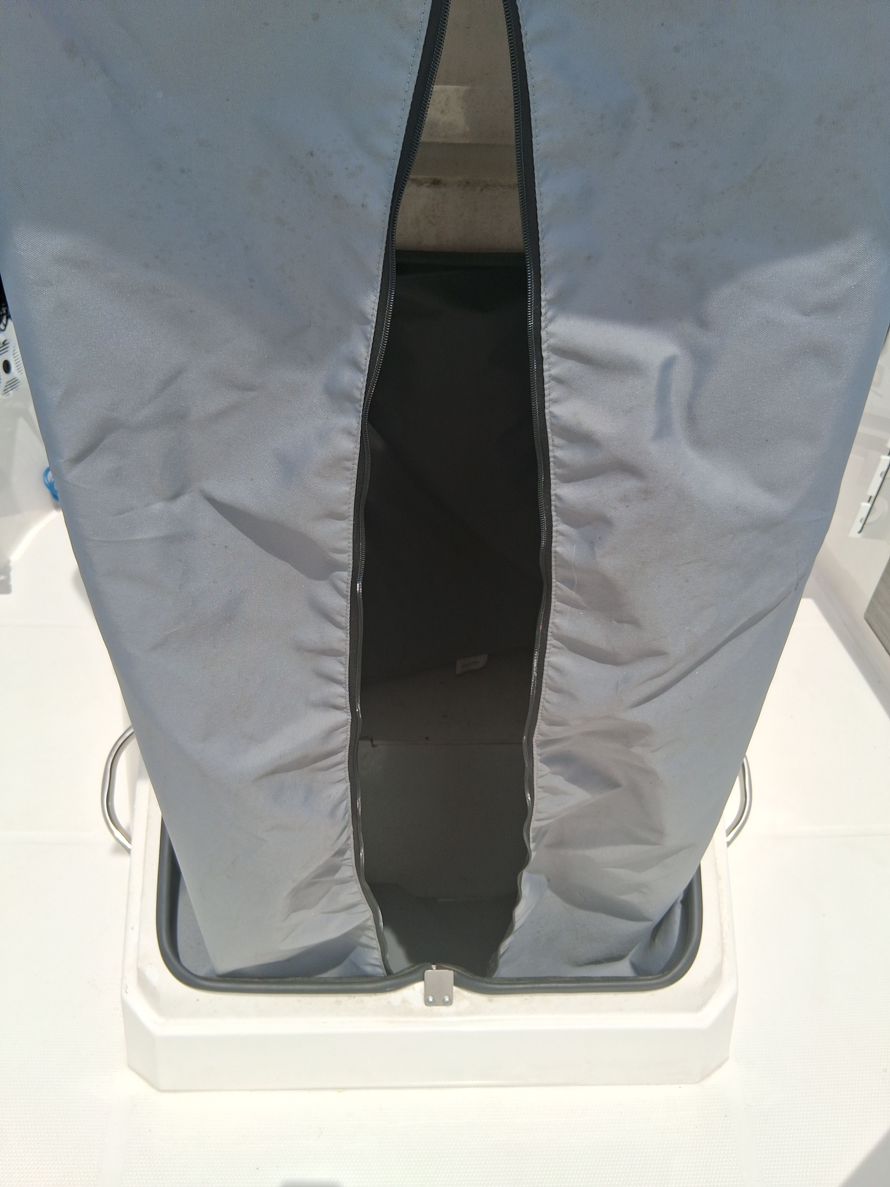 A gray, vertical storage compartment on a boat with a zipper.