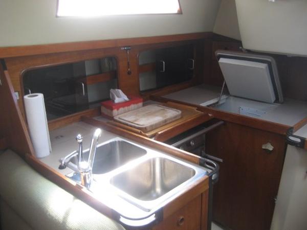 Interior of a 1984 C&C Landfall with a sink and wooden cabinetry.