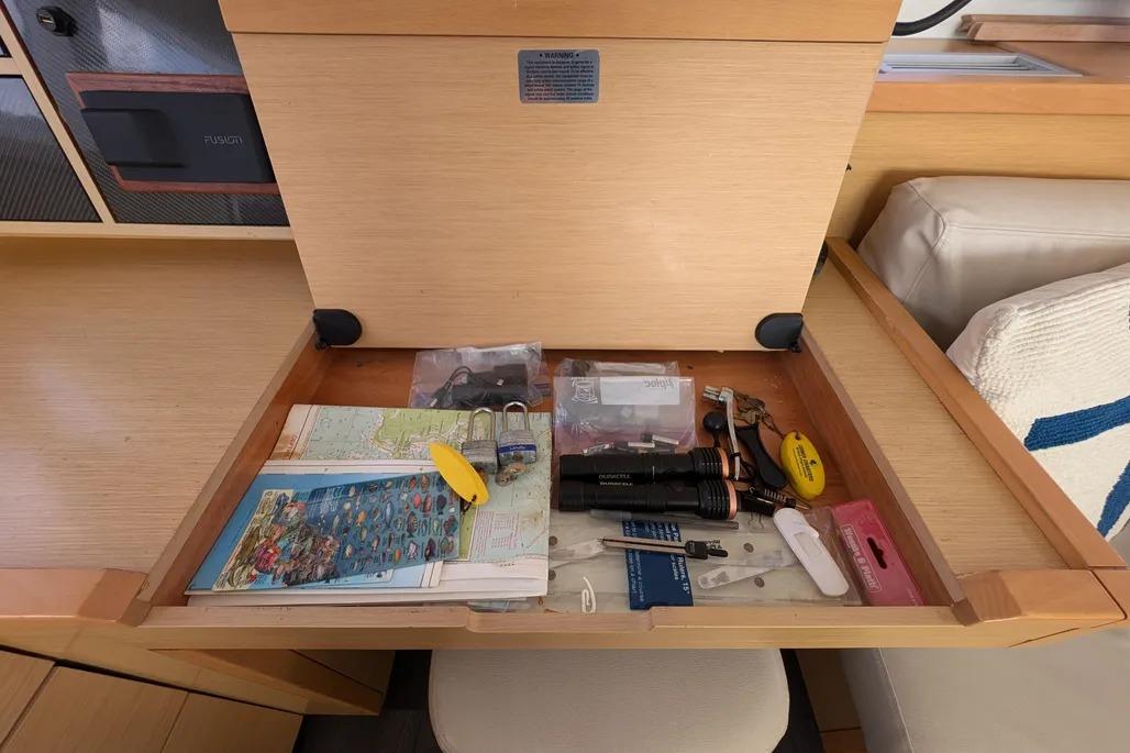 Drawer on Lagoon 450 F yacht with maps, flashlight, and miscellaneous items.