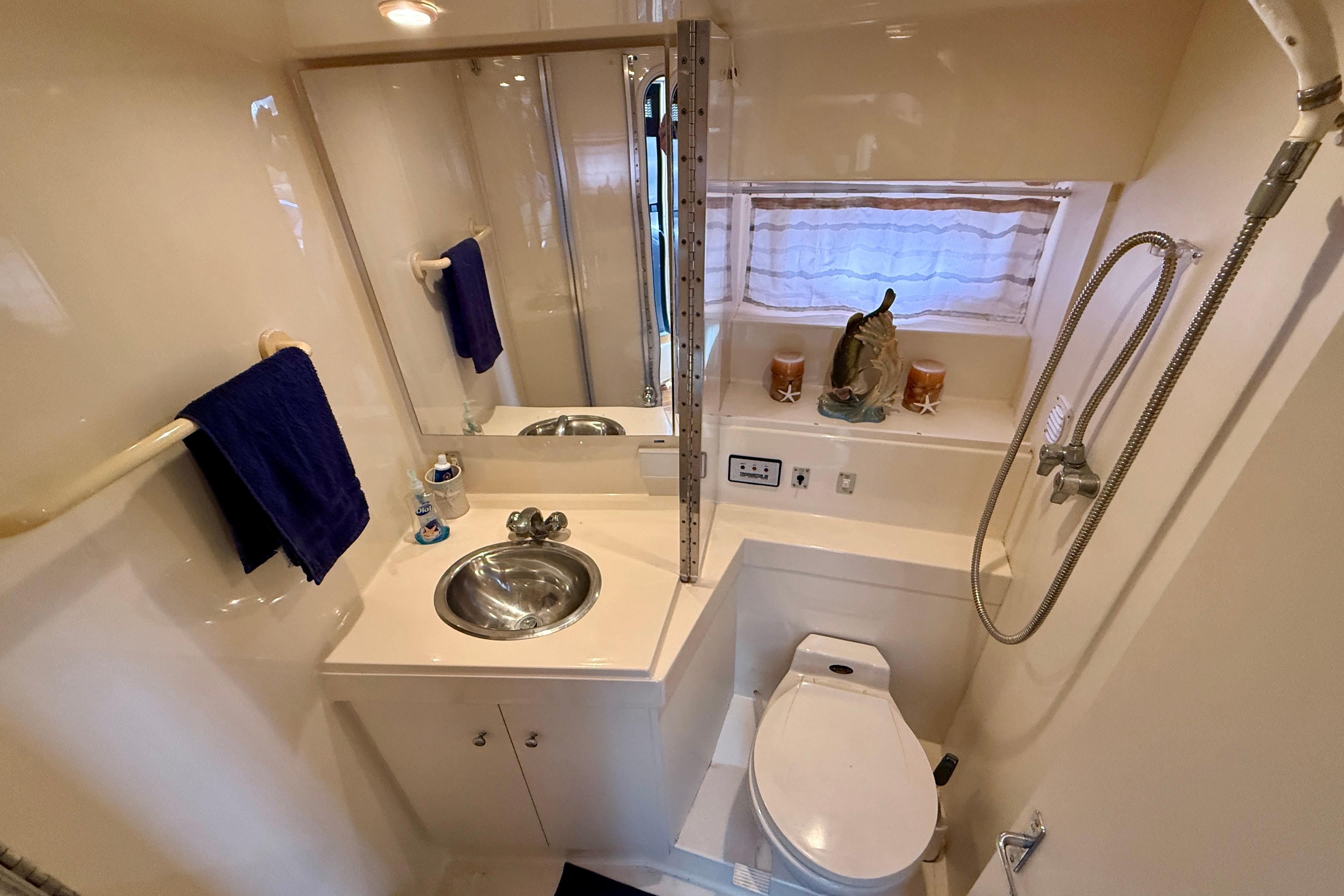 Bathroom of 1997 Carver 355 Aft Cabin Motor Yacht with sink, toilet, and shower.