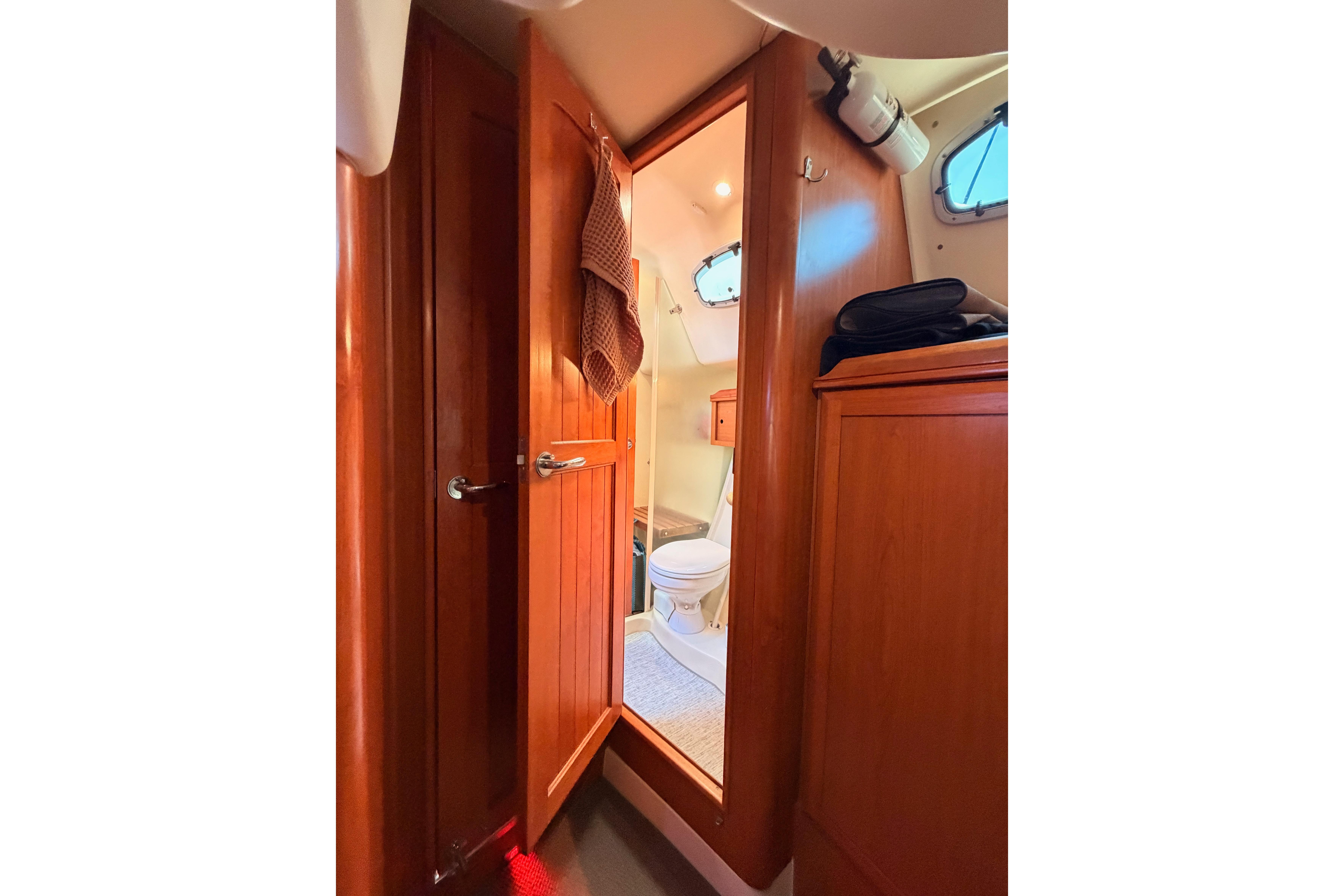 Interior view of 2008 Hunter 45 Deck Salon yacht bathroom with wooden cabinetry.