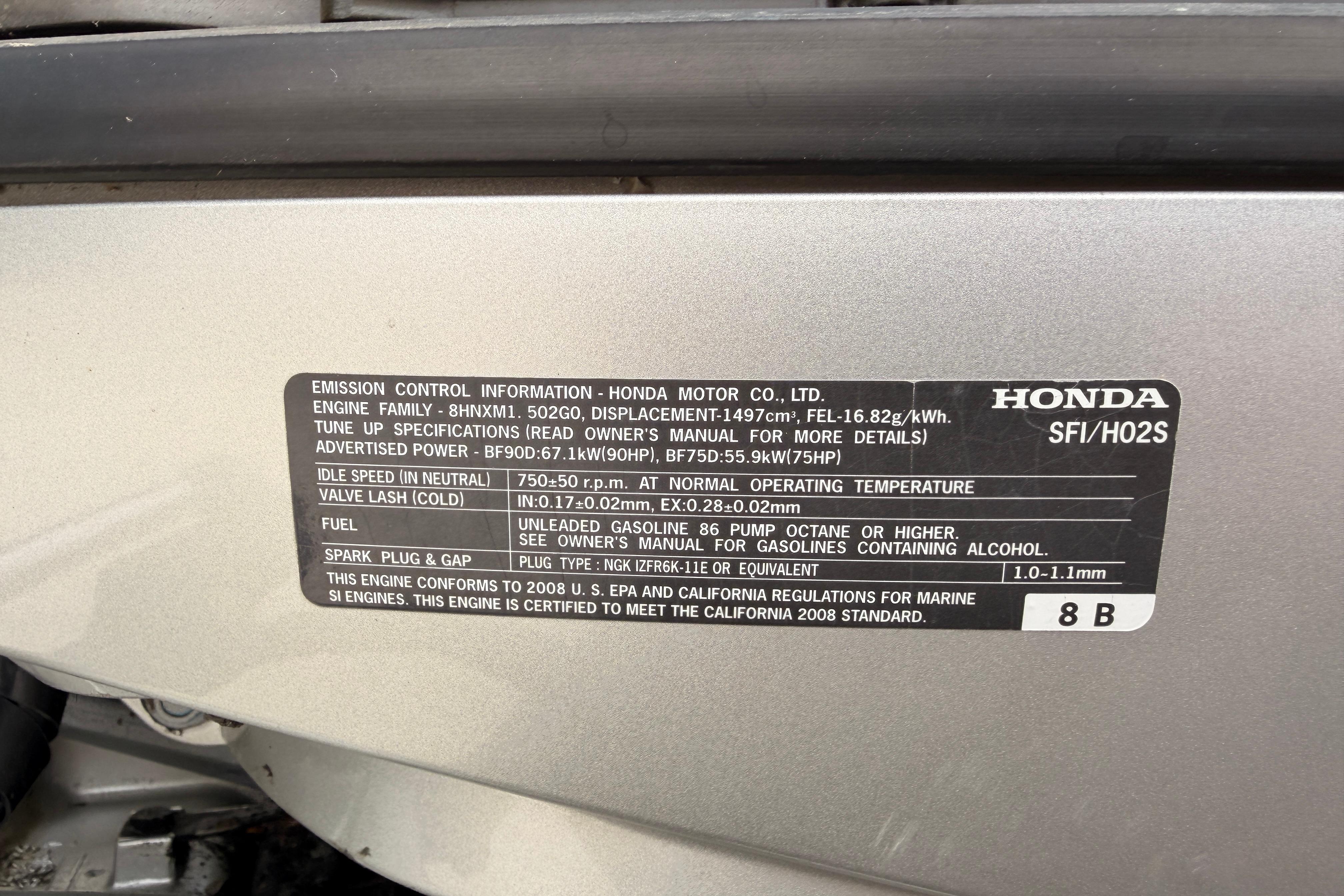 Emission control label on a Honda marine engine, detailing specifications and compliance.