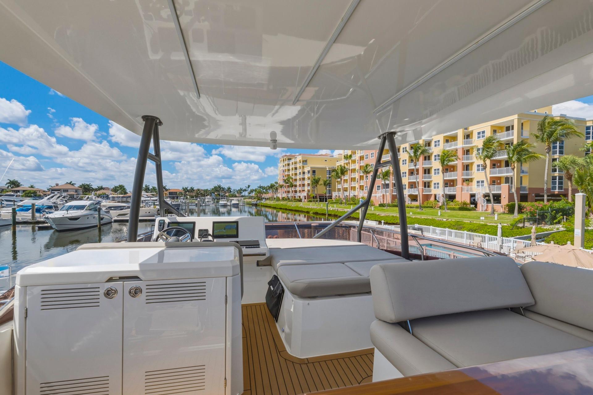Luxurious 2022 Prestige 520 yacht docked at marina with waterfront view.