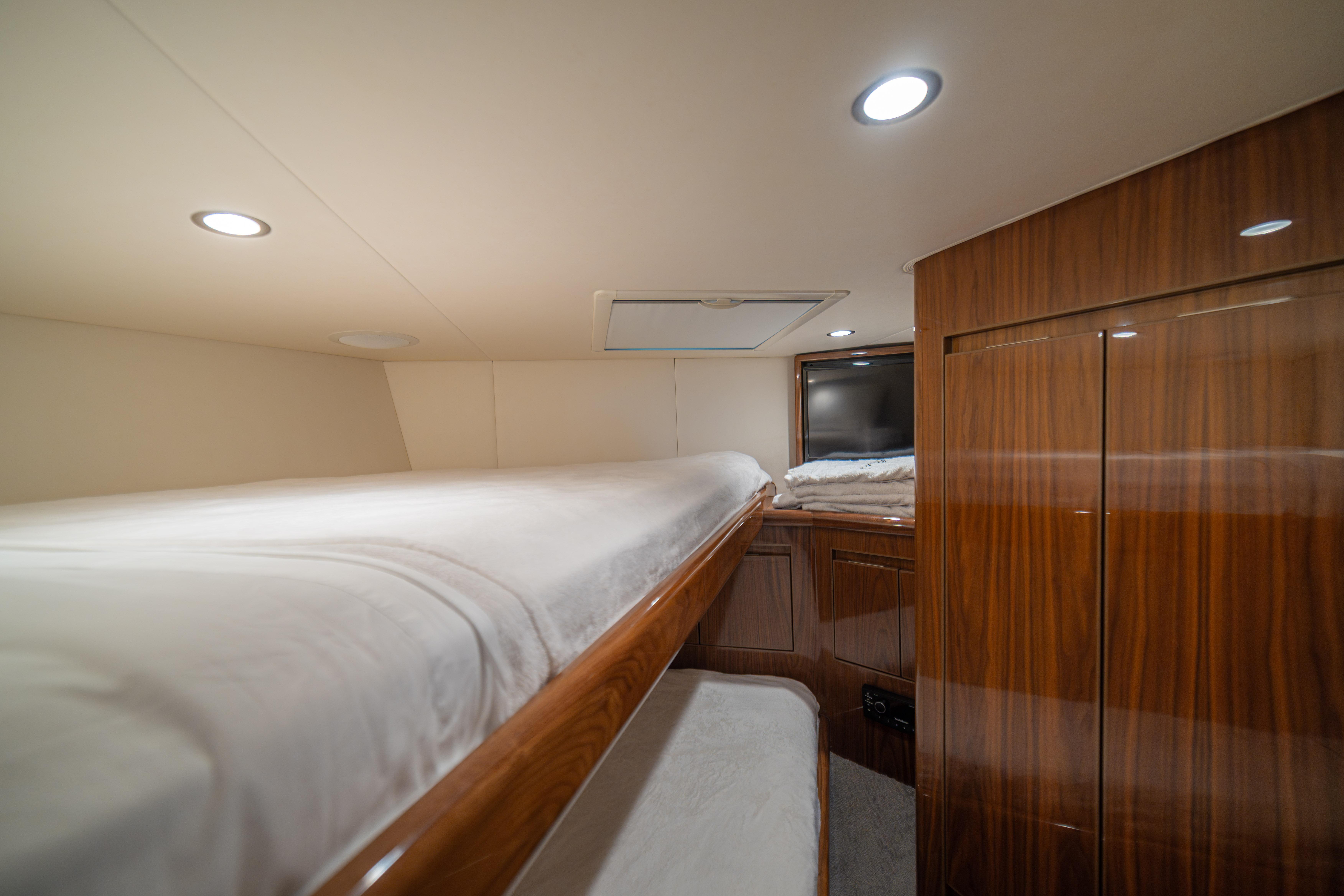 2024 Viking 48 Convertible yacht interior with cozy bunk beds and elegant wood finish.
