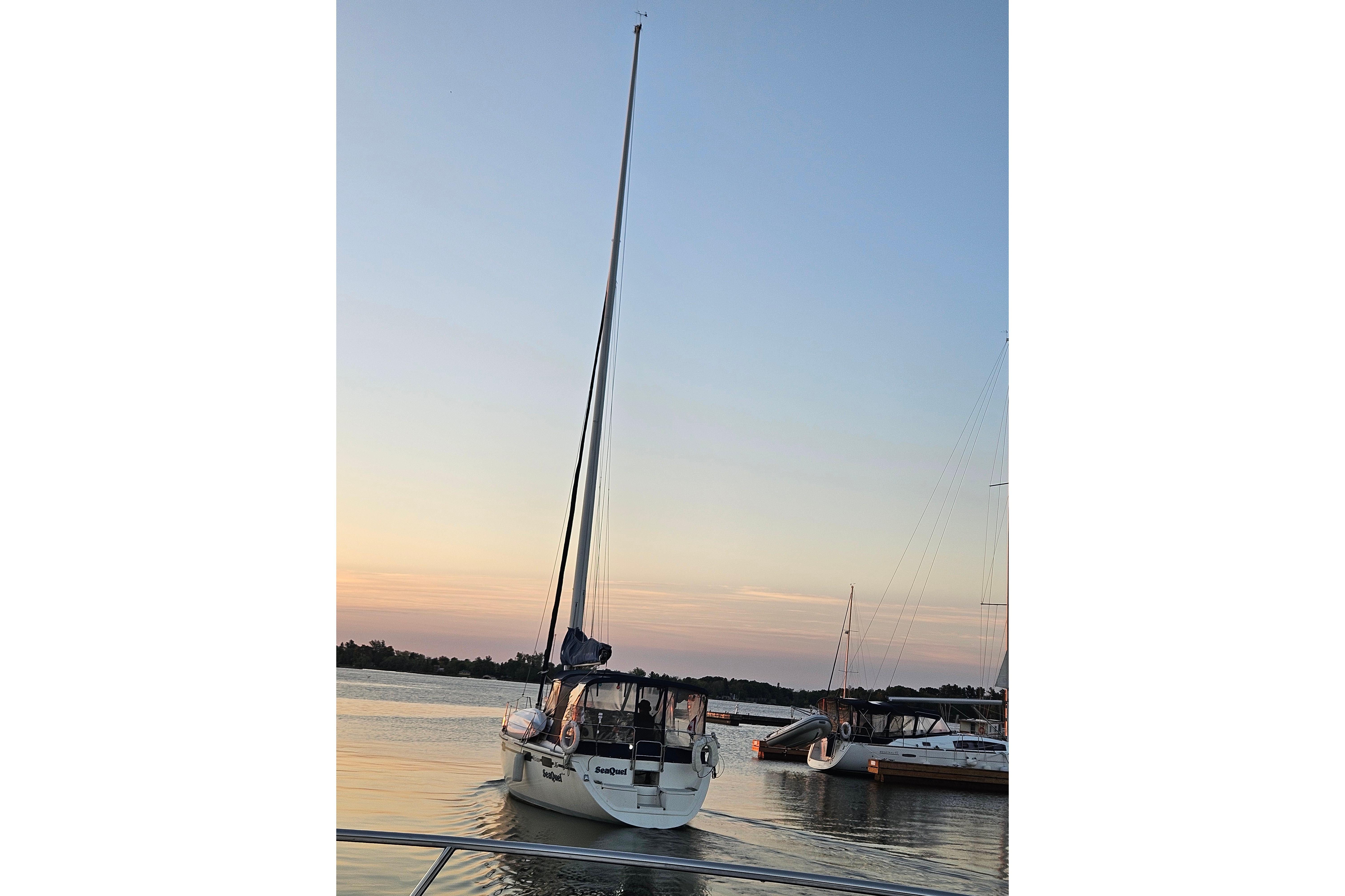 Sailboat Hunter Vision 36, 1992 model, docked at sunset on calm waters.