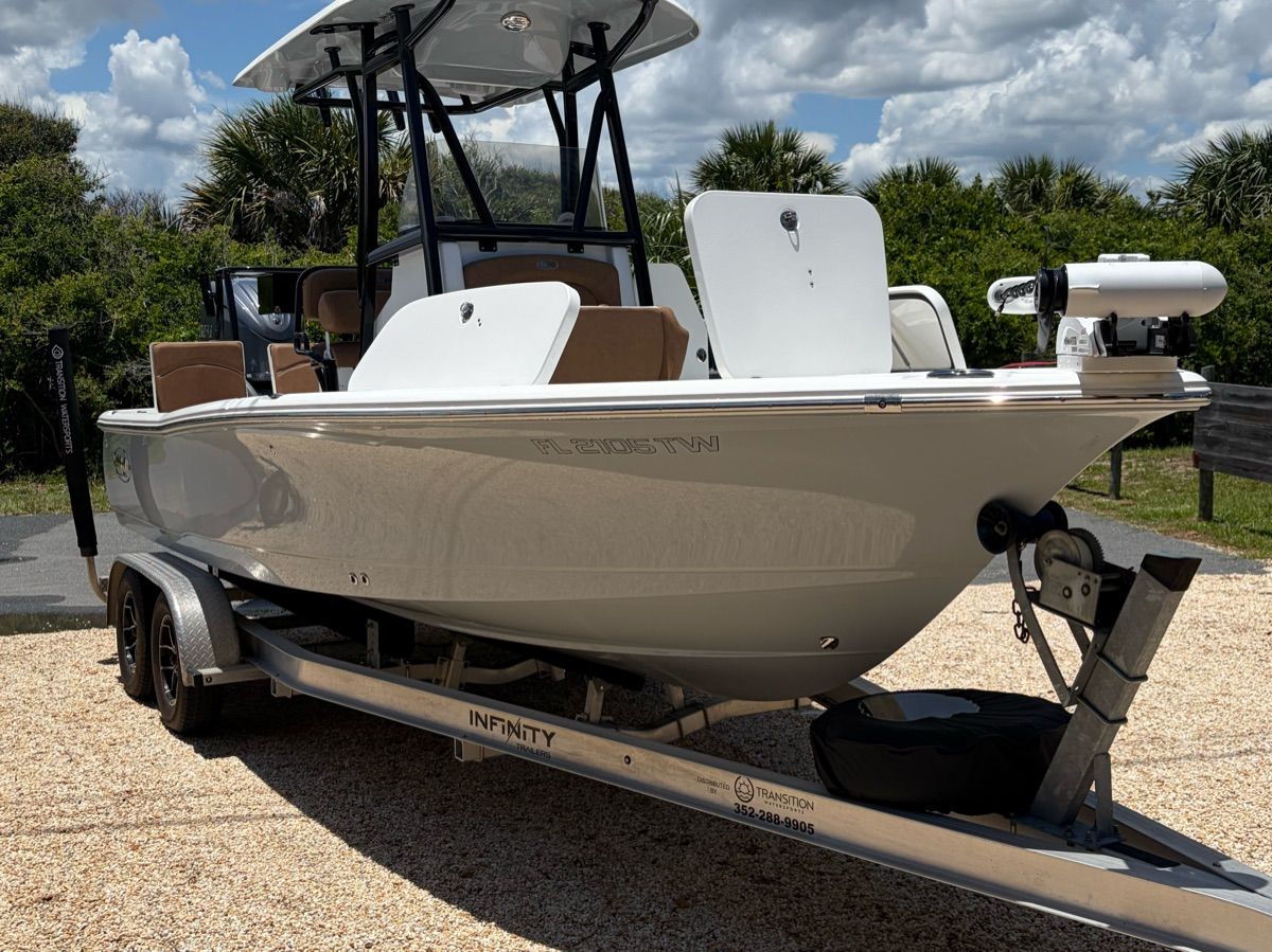 A 2023 Sea Hunt BX 22 BR boat on a trailer, surrounded by trees and sky.