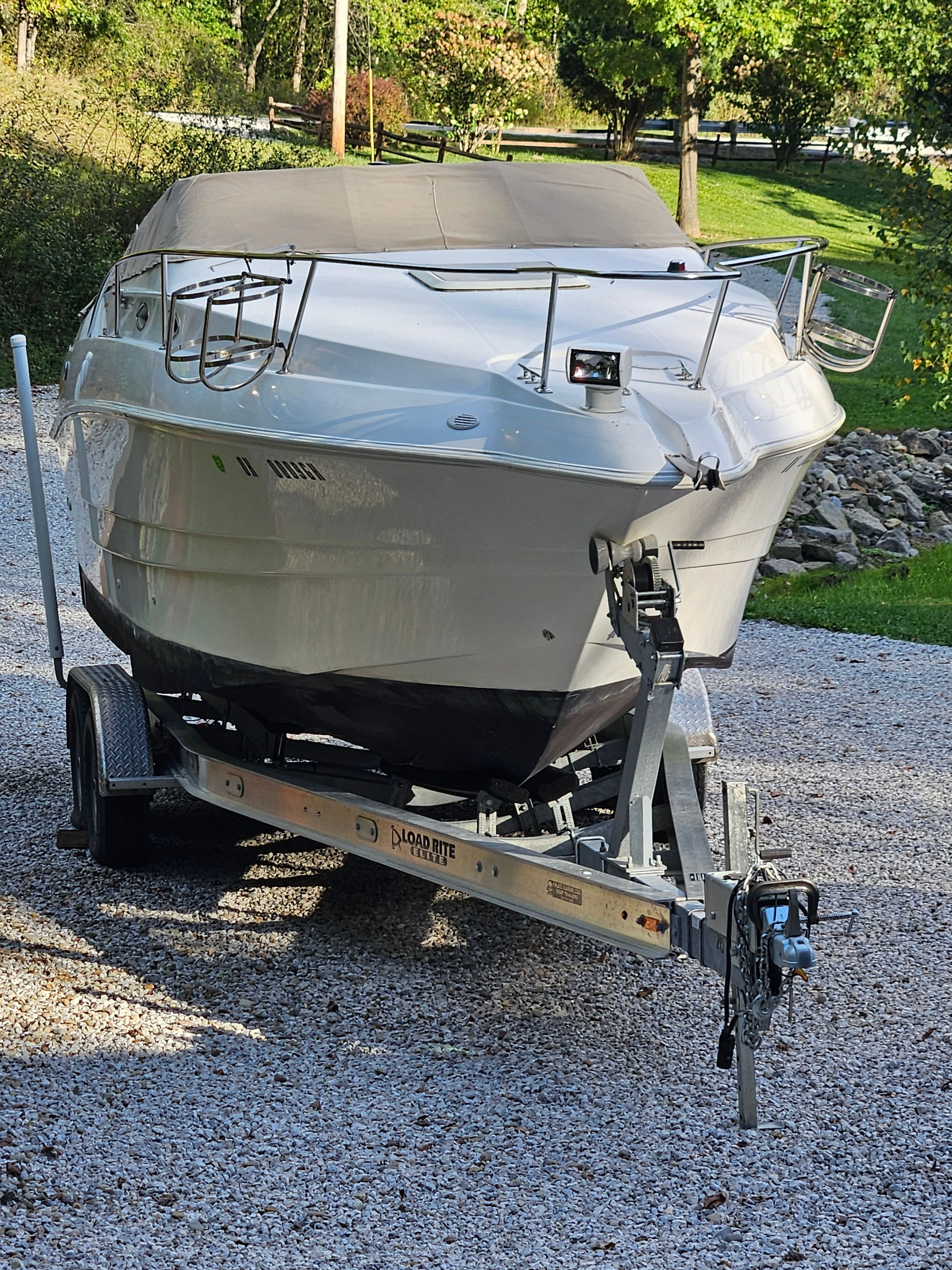 1998 Larson Cabrio 254 on a trailer outdoors.