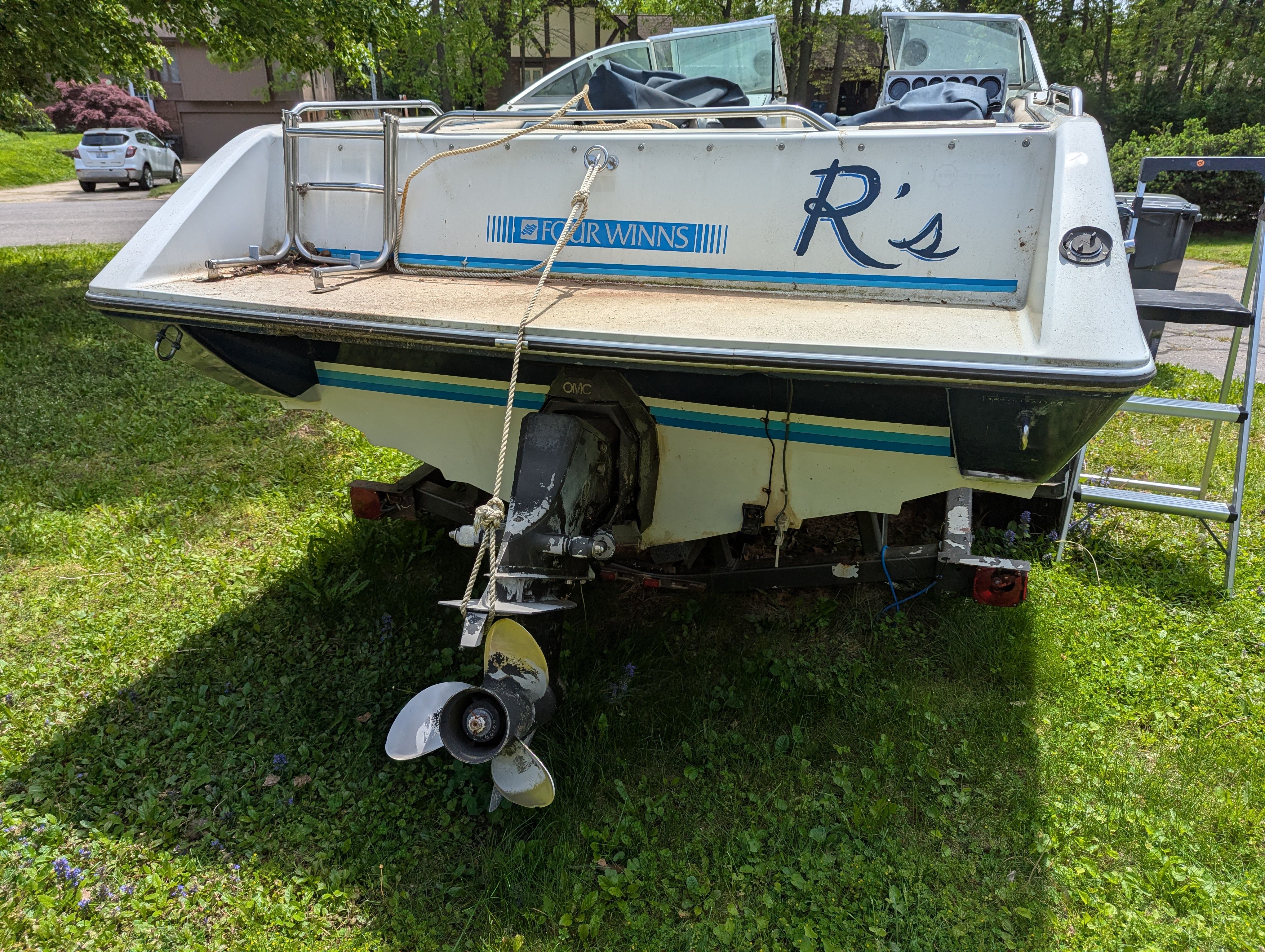 Rear view of a 1988 Four Winns 200 Horizon boat on grass.