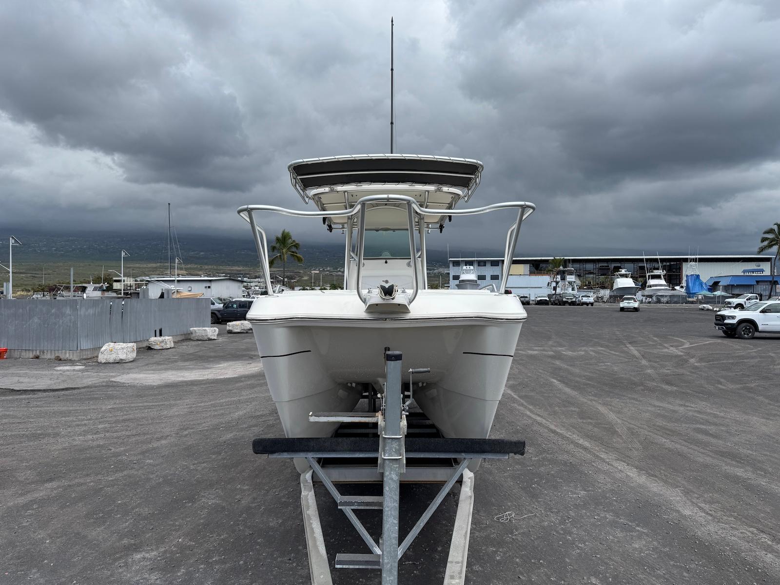 2009 World Cat 270 TE boat on trailer under cloudy sky in marina.