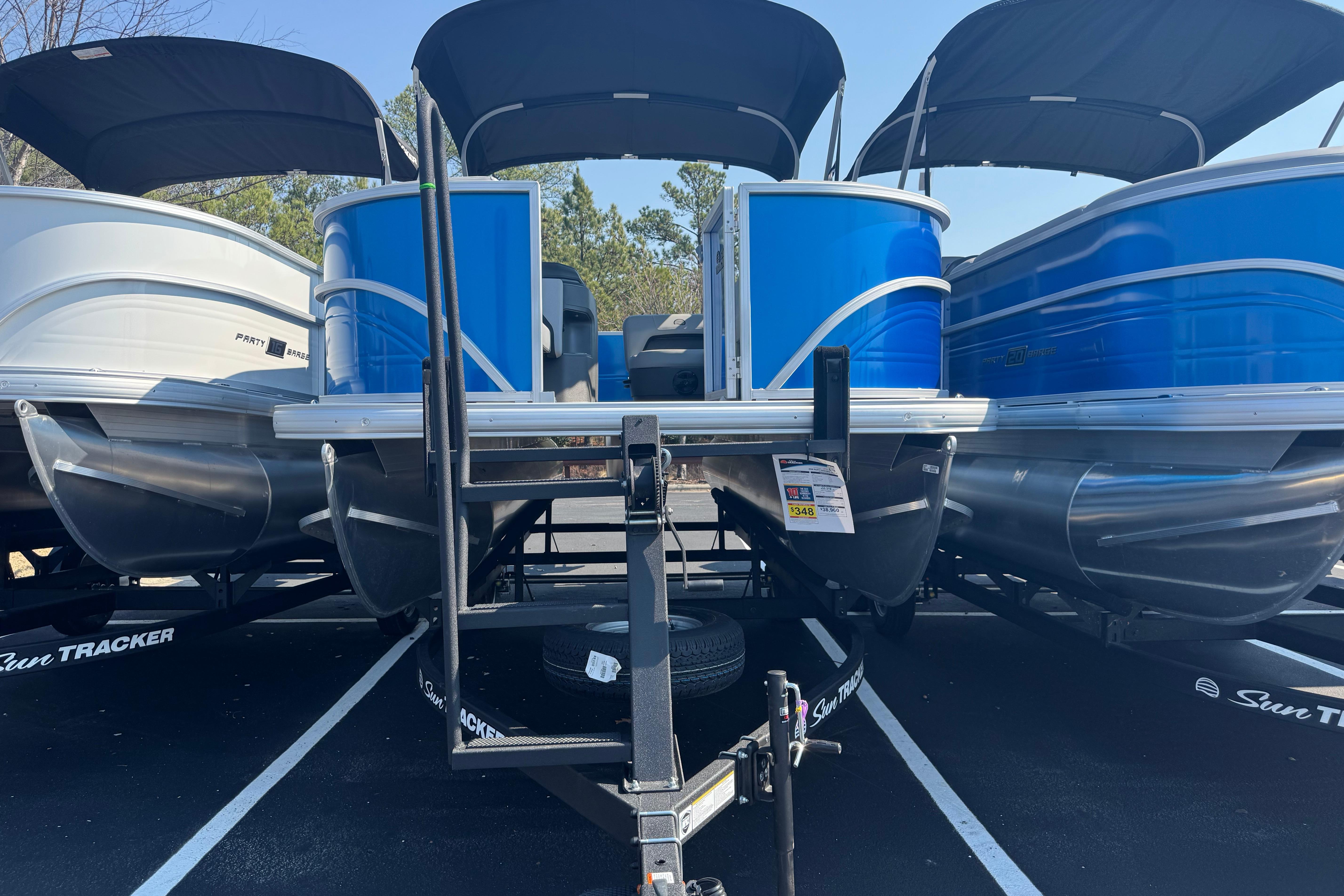 2026 Sun Tracker Party Barge 18 DLX pontoon boat with blue exterior on display.