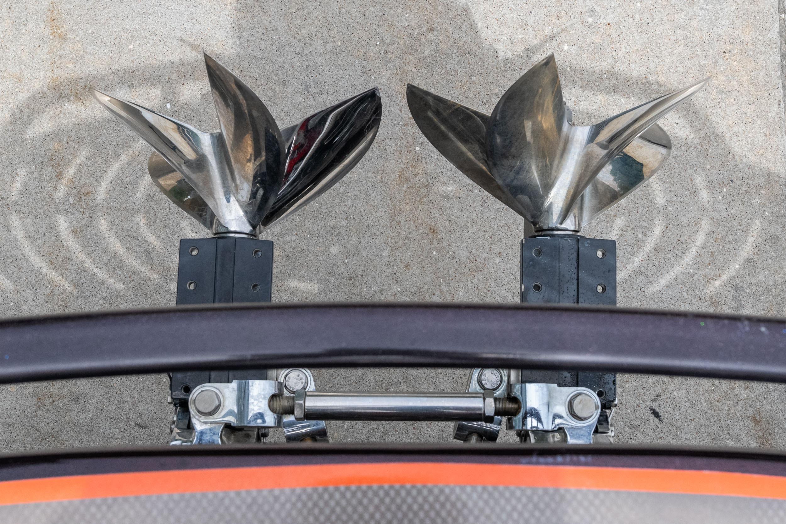 Dual propellers of a 2006 Cigarette 39' Top Gun Unlimited boat on concrete surface.