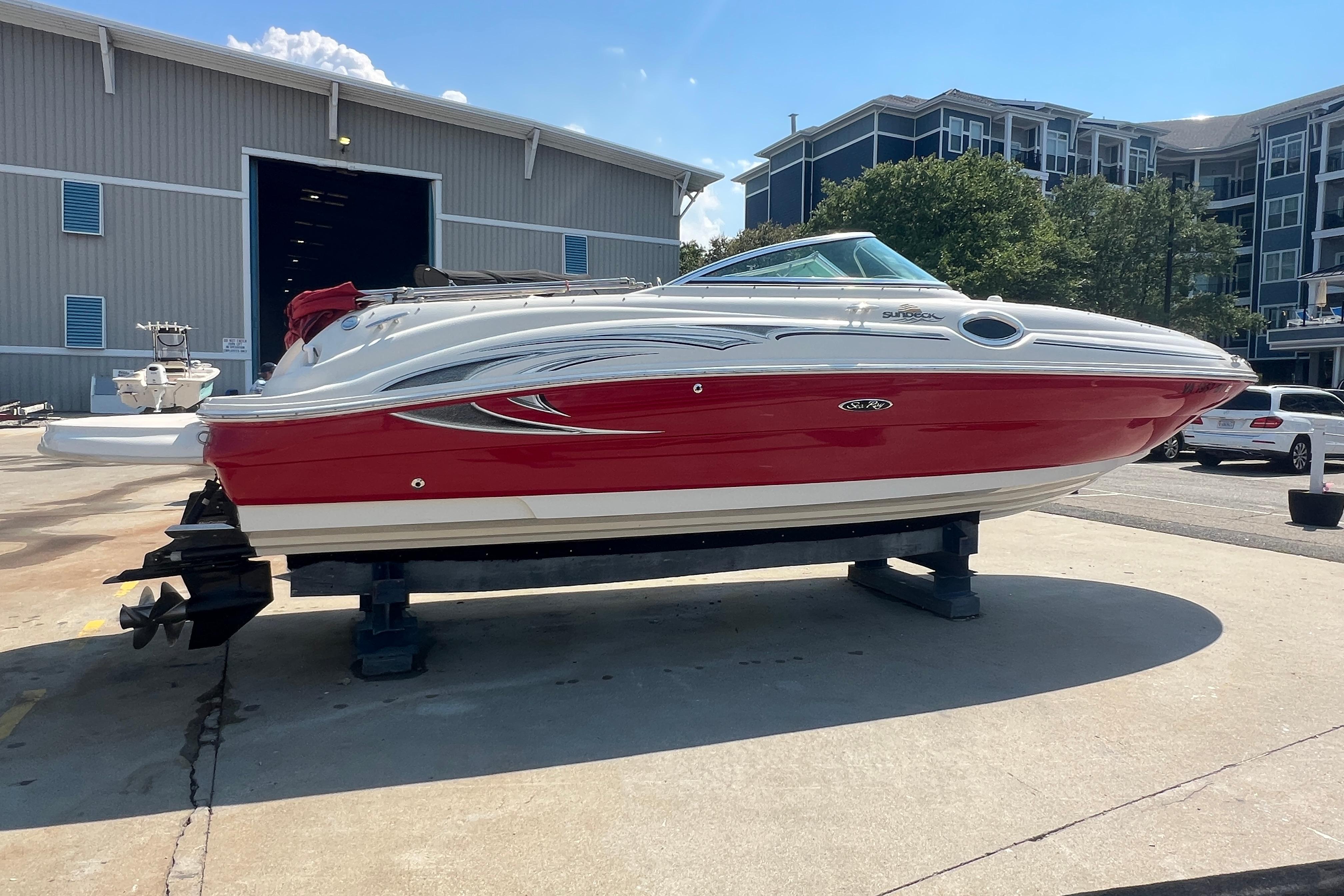 2005 Sea Ray 240 Sundeck boat with red and white exterior on display at a marina.