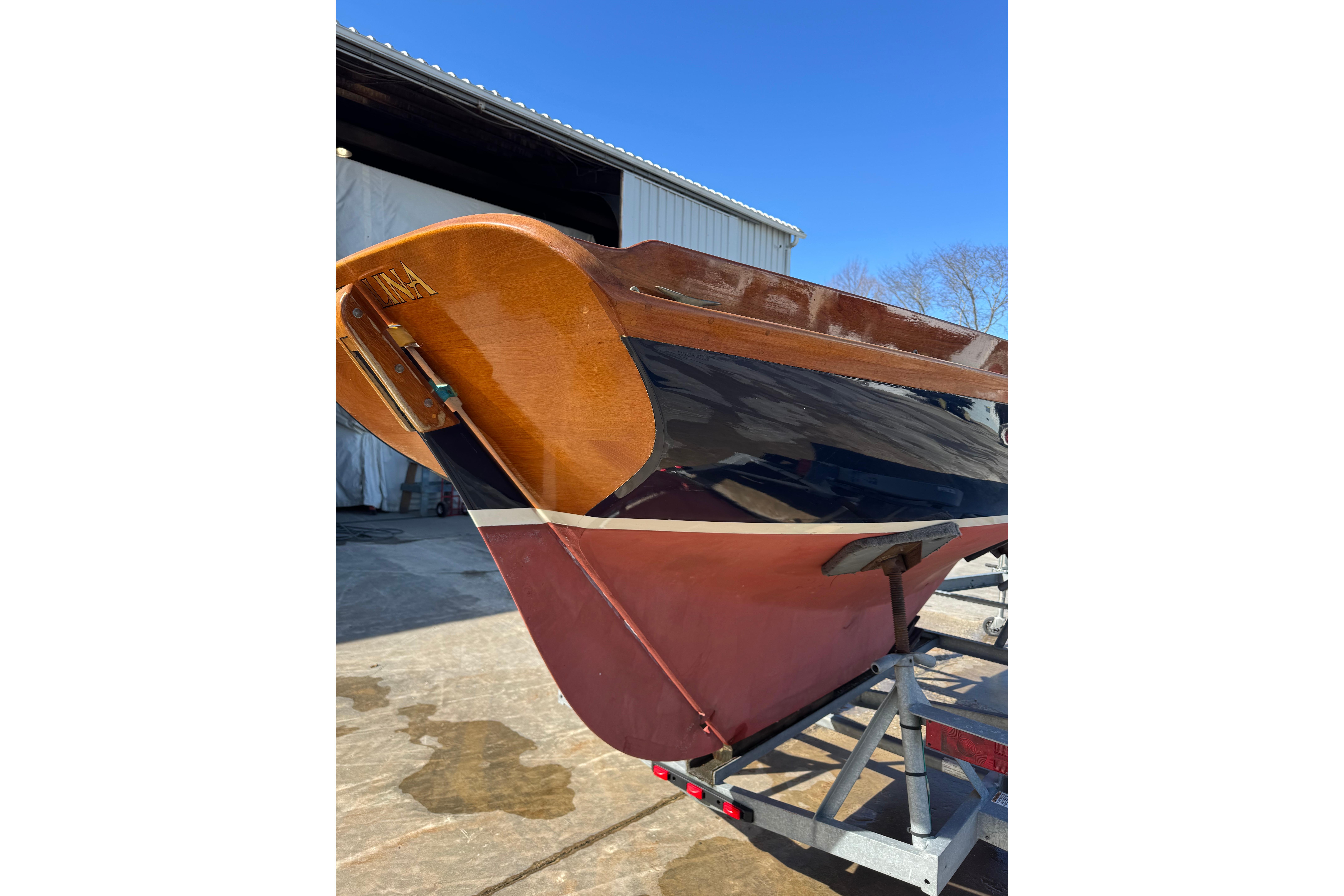 2018 Ballentine's Boat Shop Doughdish sailboat on trailer, showcasing polished wooden hull.