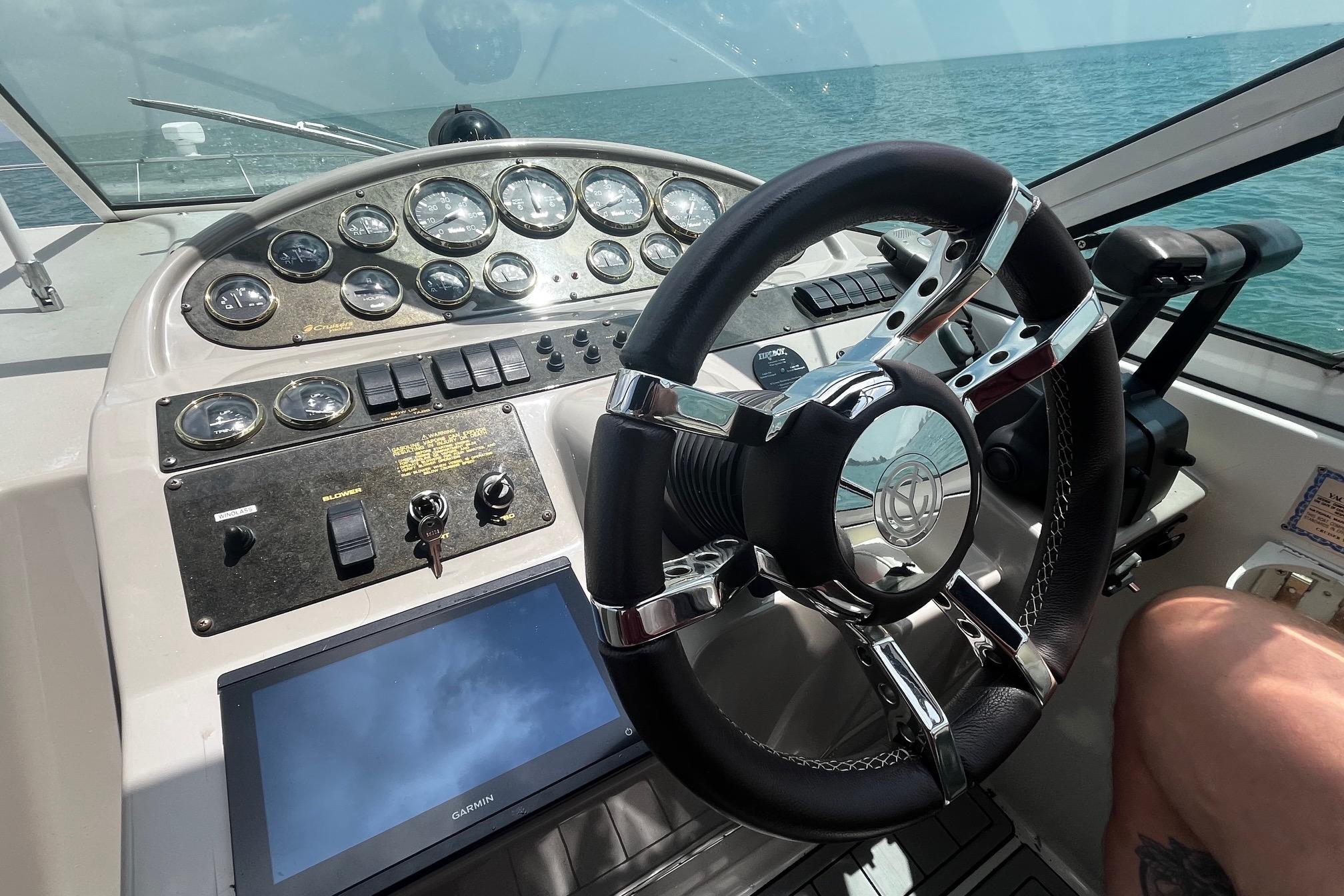 Steering wheel and dashboard of 2004 Cruisers Yachts 280 CXi Express on open water.