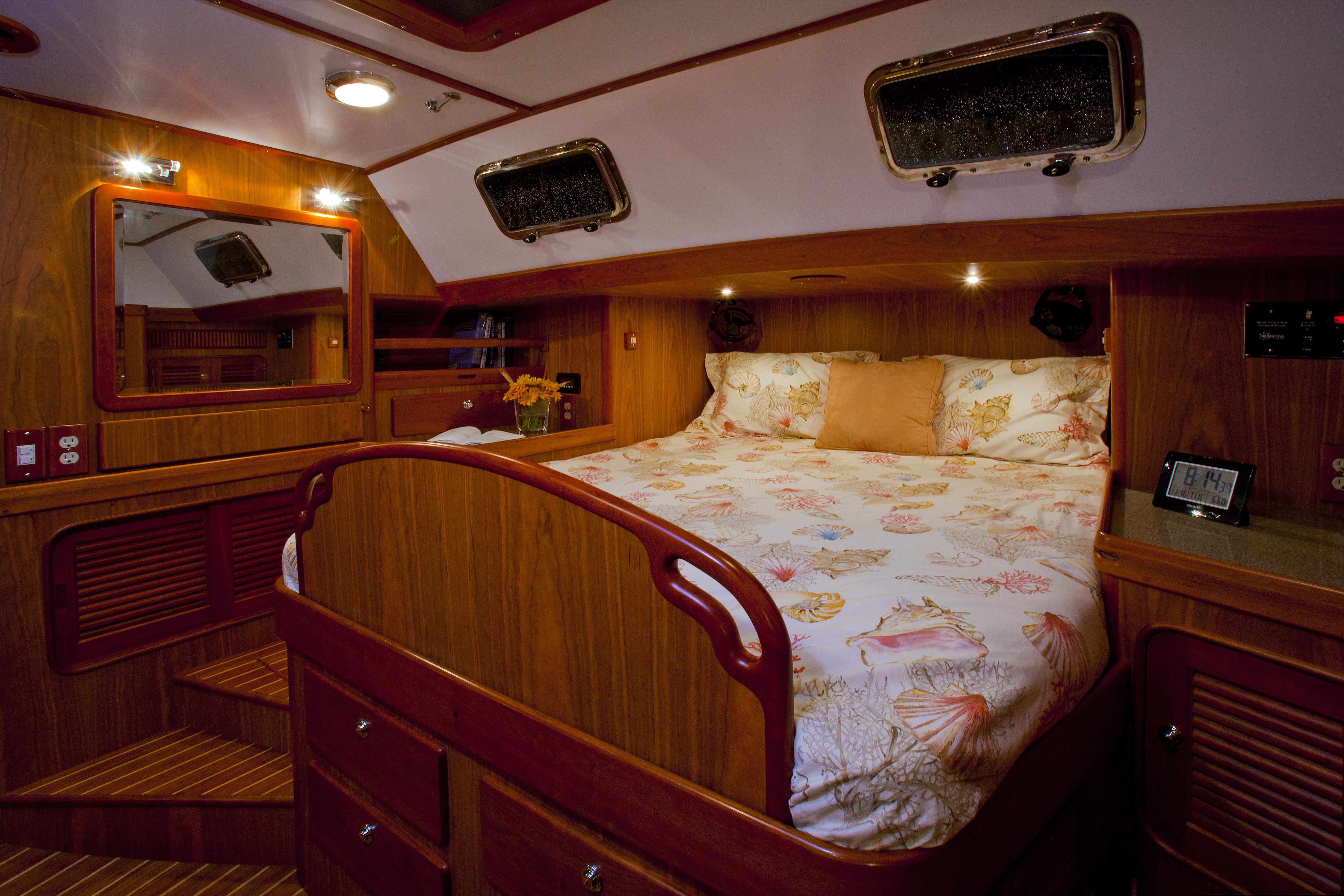 Luxurious cabin interior of 2013 Passport 470 Center Cockpit yacht with cozy bed and wooden finish.