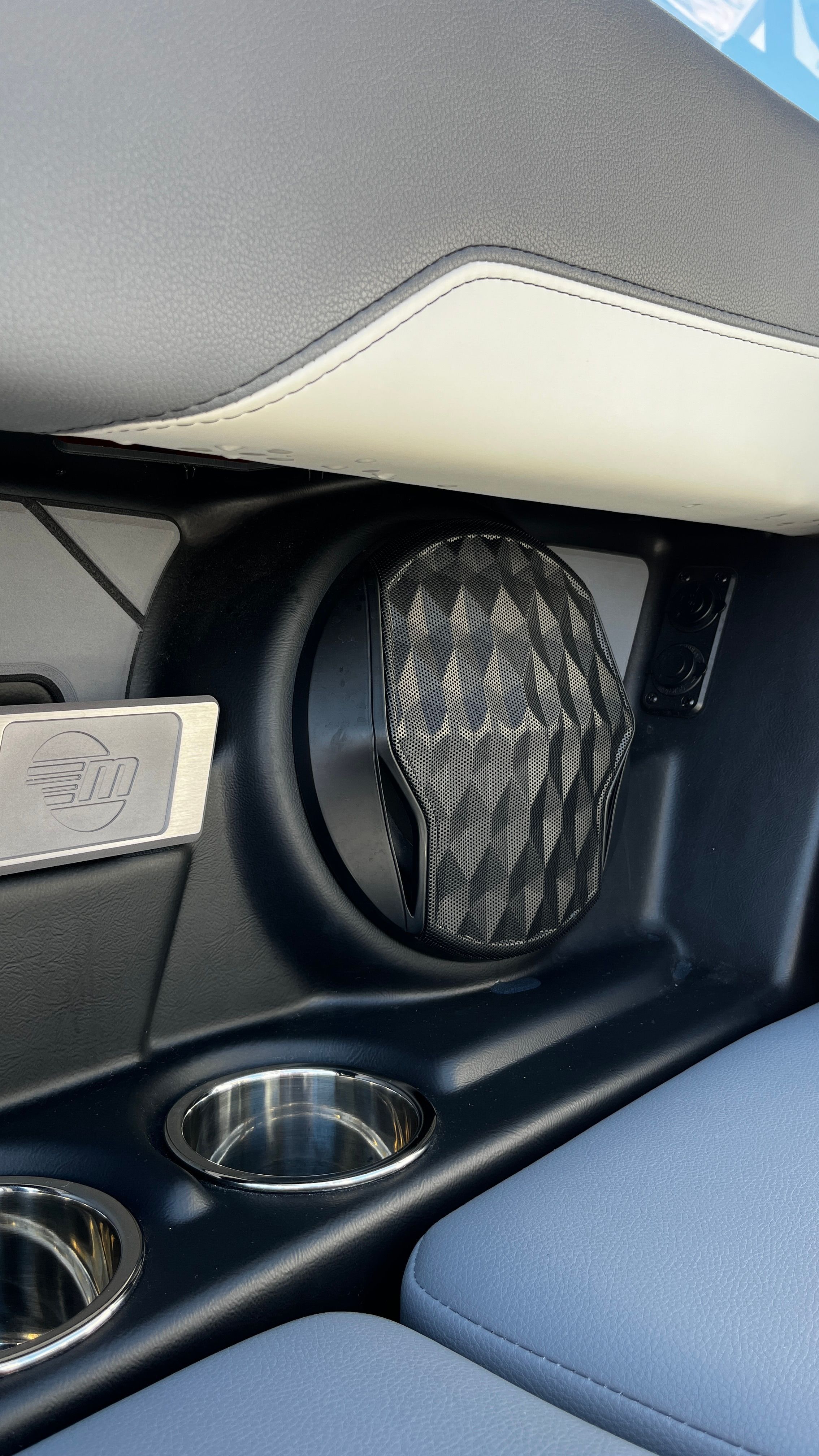 Close-up of a speaker and cup holders in a boat.
