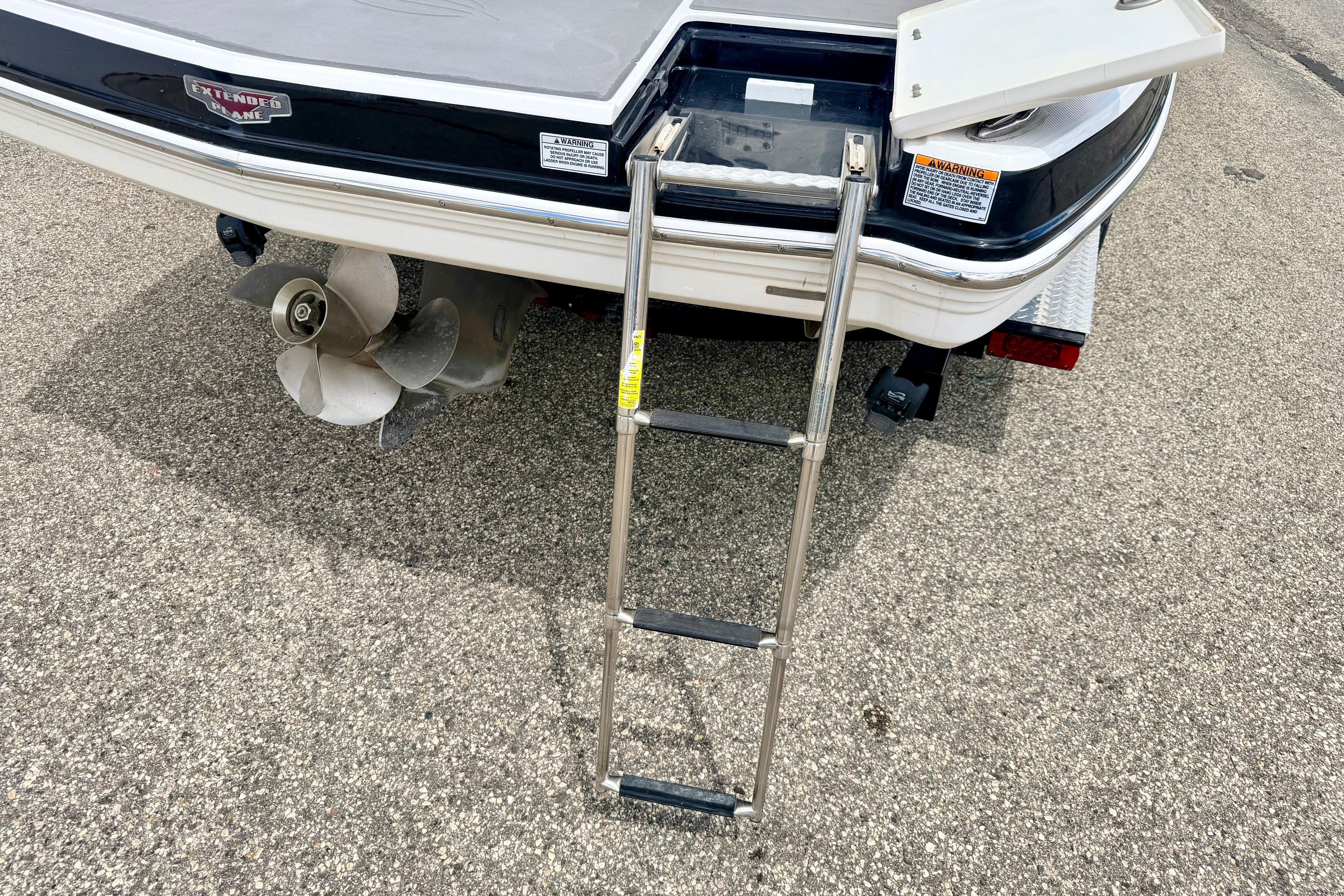 2015 Chaparral Sunesta 264 boat stern with ladder and propeller on pavement.
