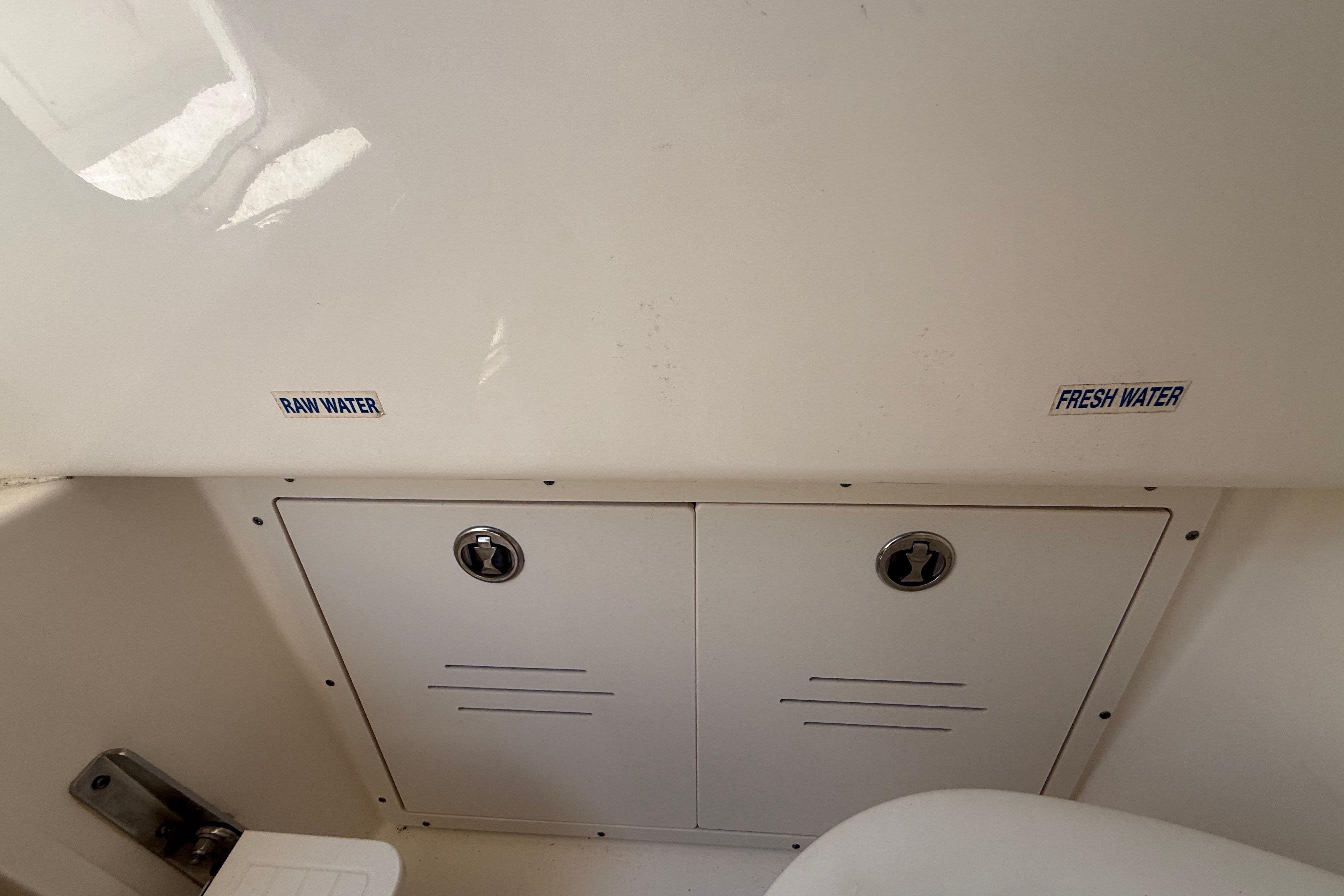 2019 Key West Billistic 281 Center Console water access panel with raw and fresh water labels.