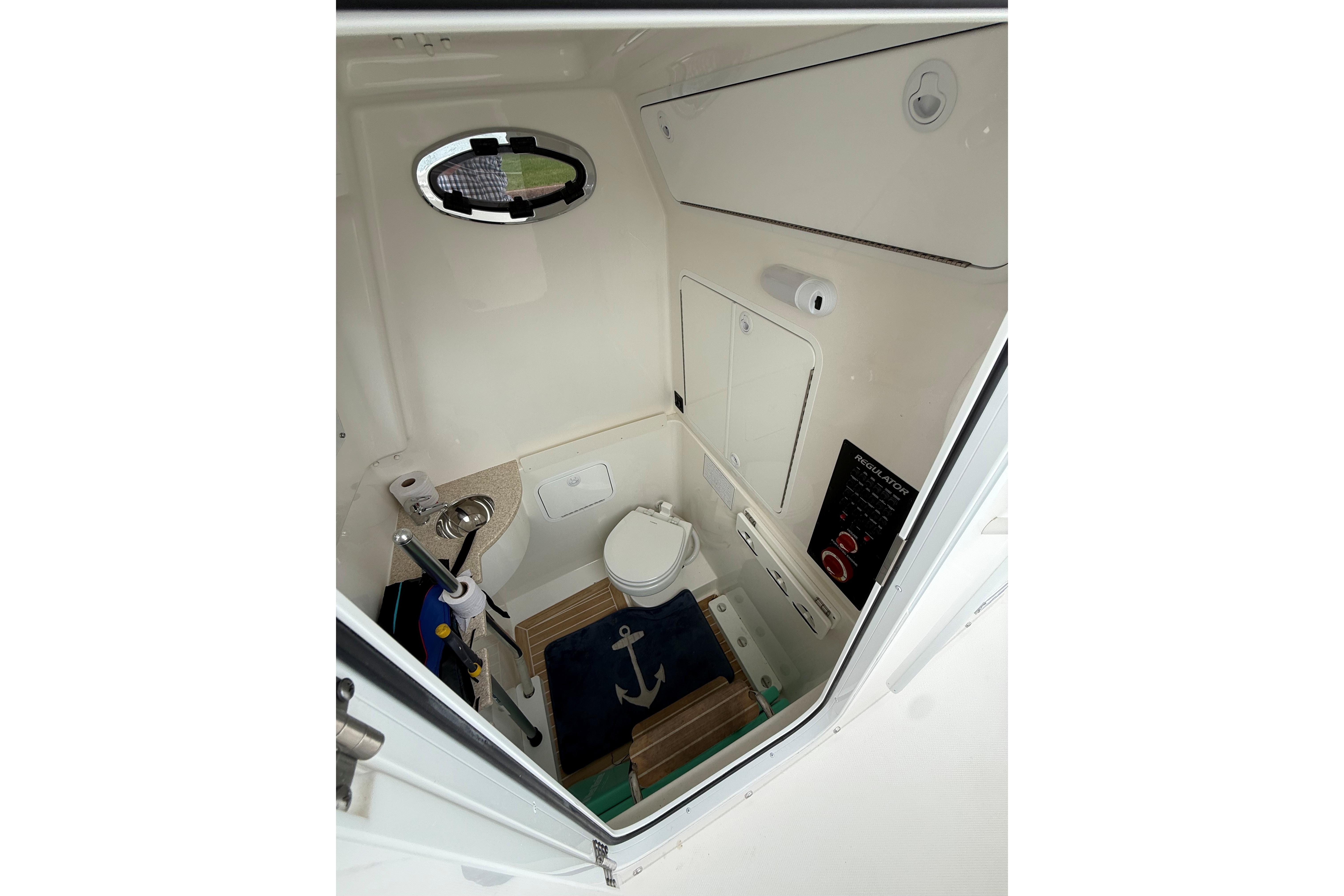 2021 Regulator 31 boat interior with compact bathroom and nautical decor.