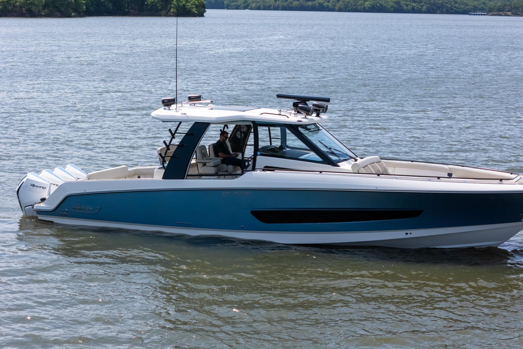 2021 Boston Whaler 420 Outrage boat on calm water, side view.