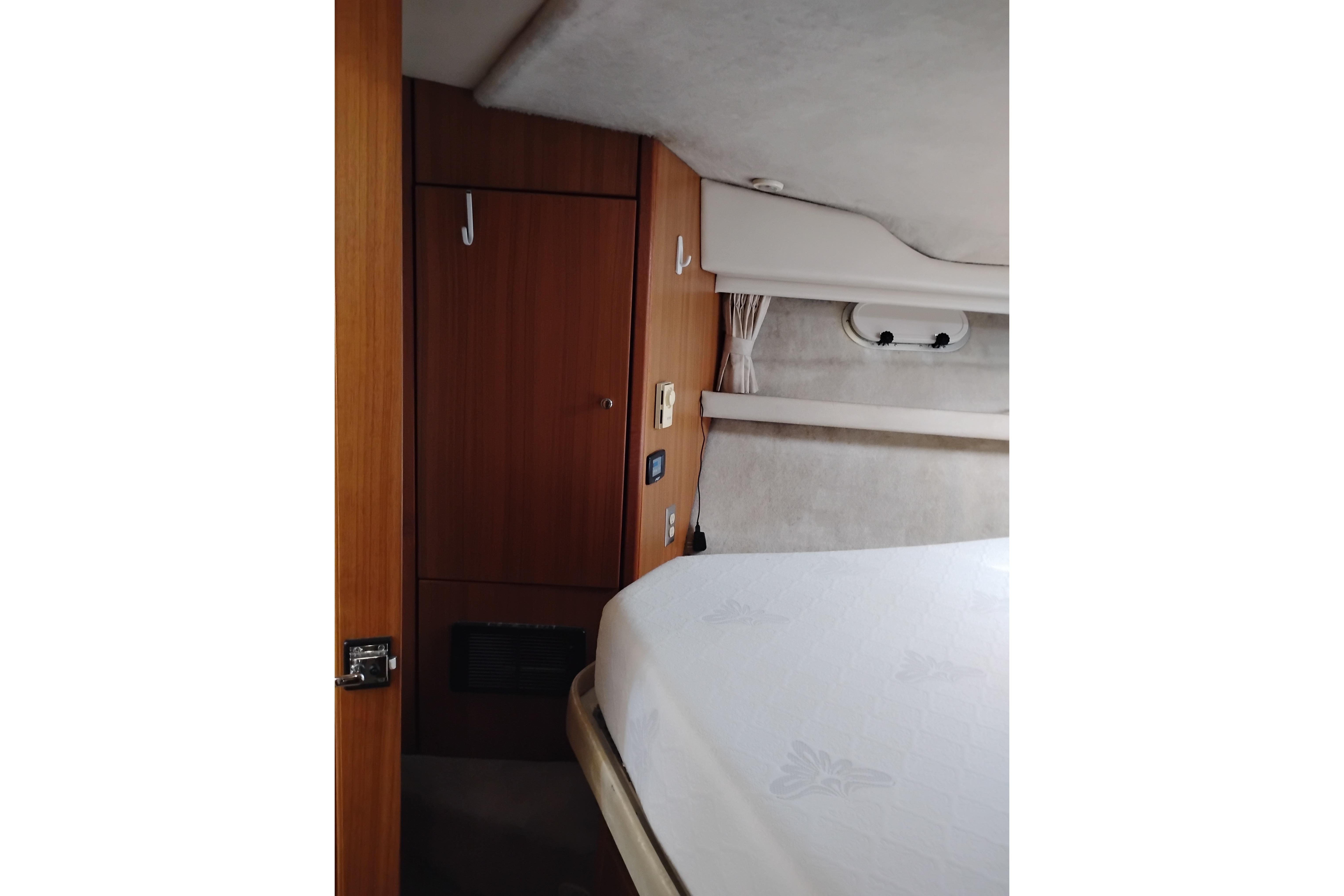 Interior cabin of 2000 Bayliner 3988 Command Bridge Motoryacht, featuring wood paneling and bed.