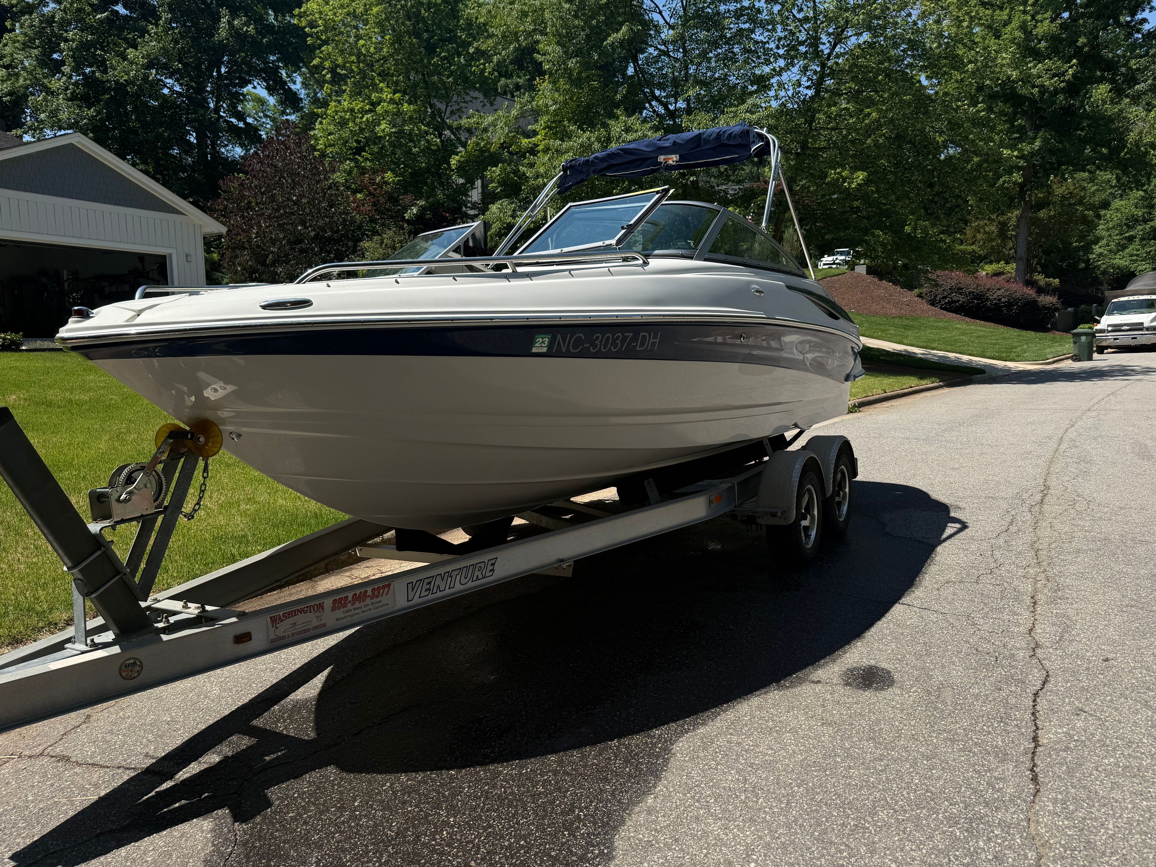 2008 Crownline 210 LX boat on trailer in residential street.