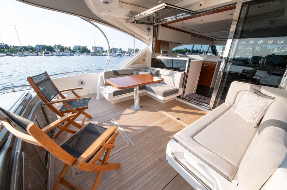 Luxurious 2022 Riviera 6000 Sport Yacht Platinum interior with elegant seating and waterfront view.