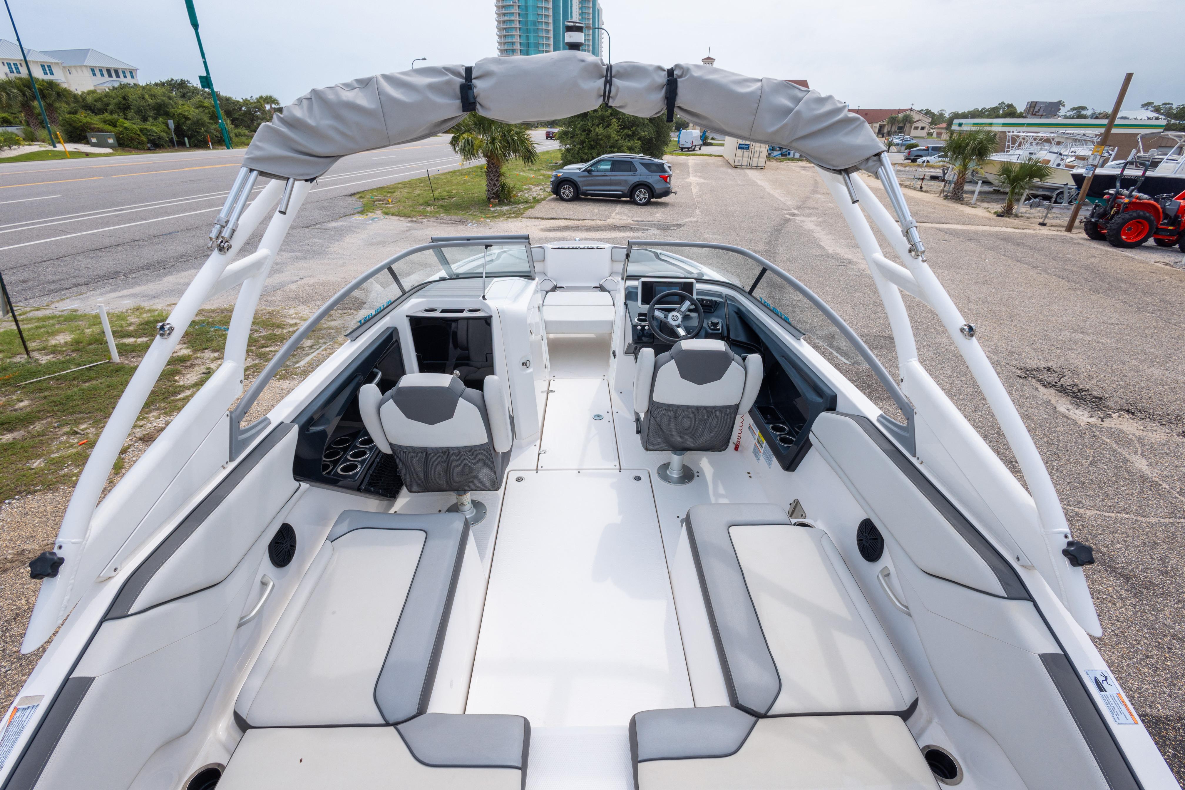2021 Yamaha Boats AR250 interior with seating and steering wheel, parked near a road.