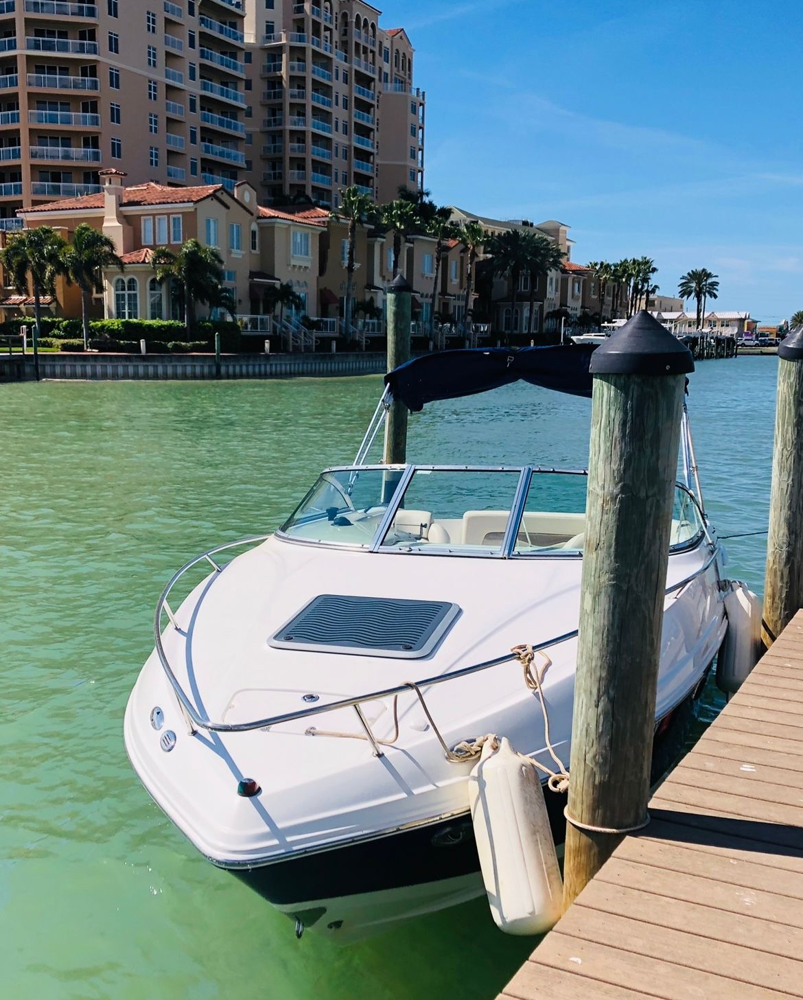 A 2007 Chaparral 235 SSi docked in clear, turquoise water near waterfront buildings.