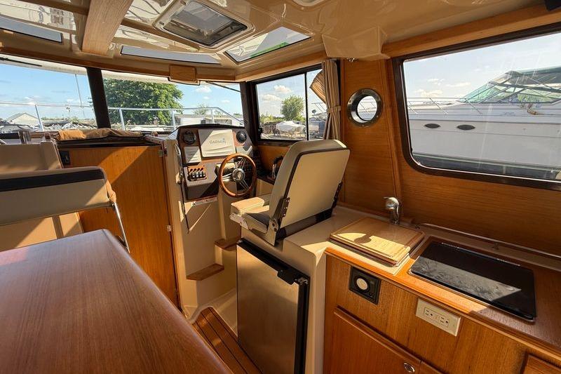Interior of 2019 Ranger Tugs R-23 boat with helm, seating, and kitchenette.