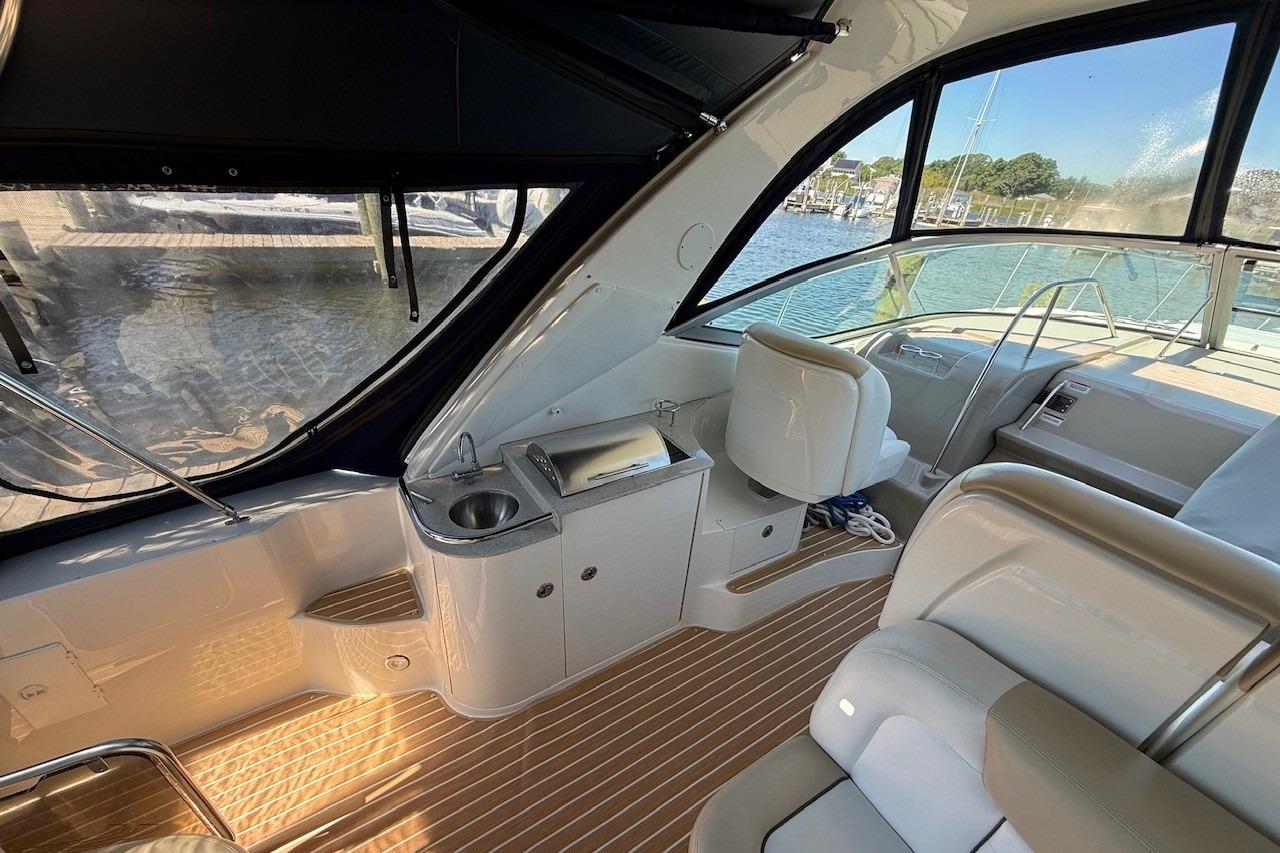 Interior of 2008 Sea Ray Sundancer 330 yacht with seating and kitchenette, docked by water.