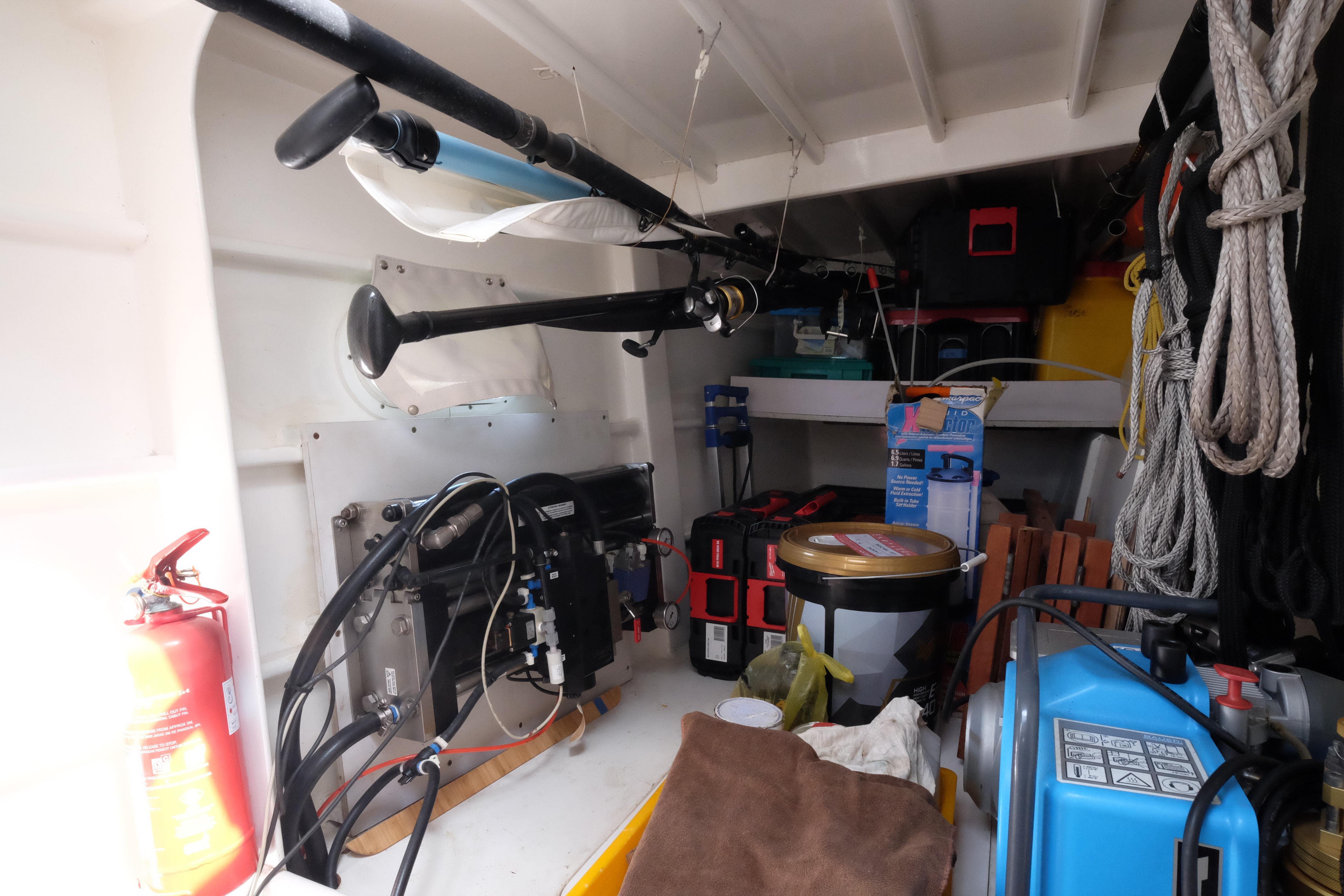 Storage area in a 2003 Punch 1500 boat with equipment, tools, and a fire extinguisher.