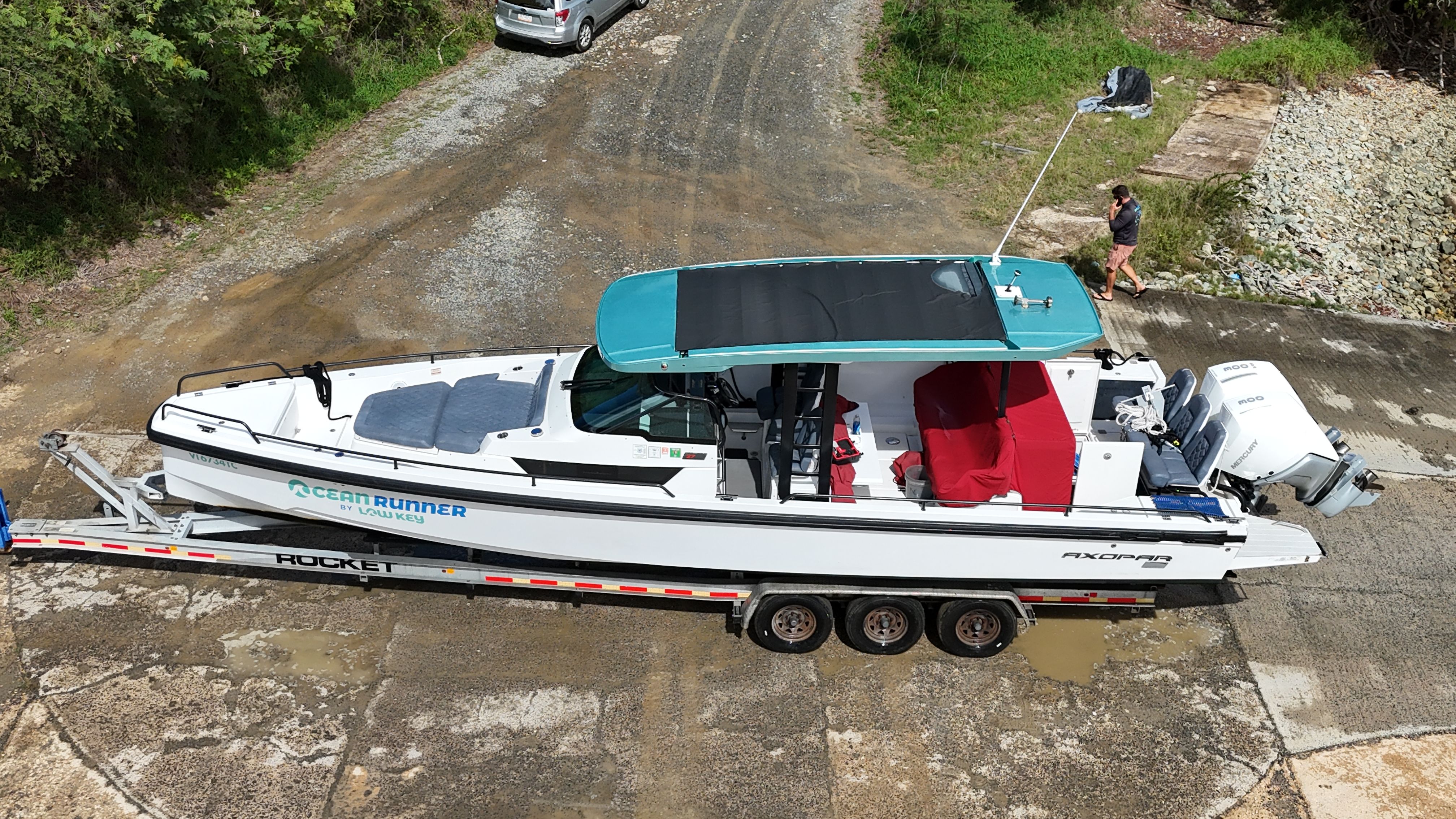 A 2020 Axopar 37 SUN TOP on a trailer, featuring red interior and blue roof.
