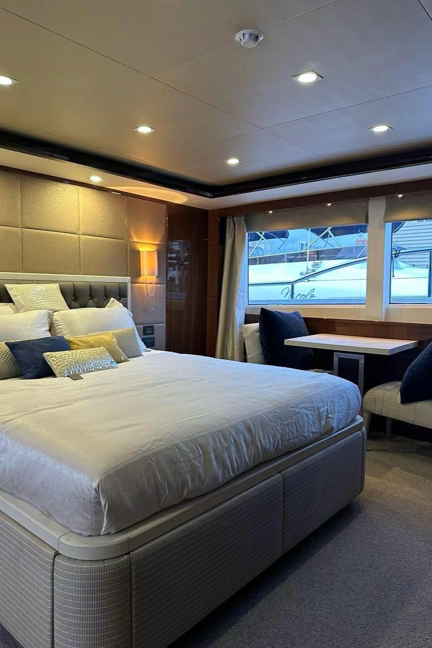 Luxurious bedroom on 2013 Princess M Class 32M yacht with elegant decor and large windows.
