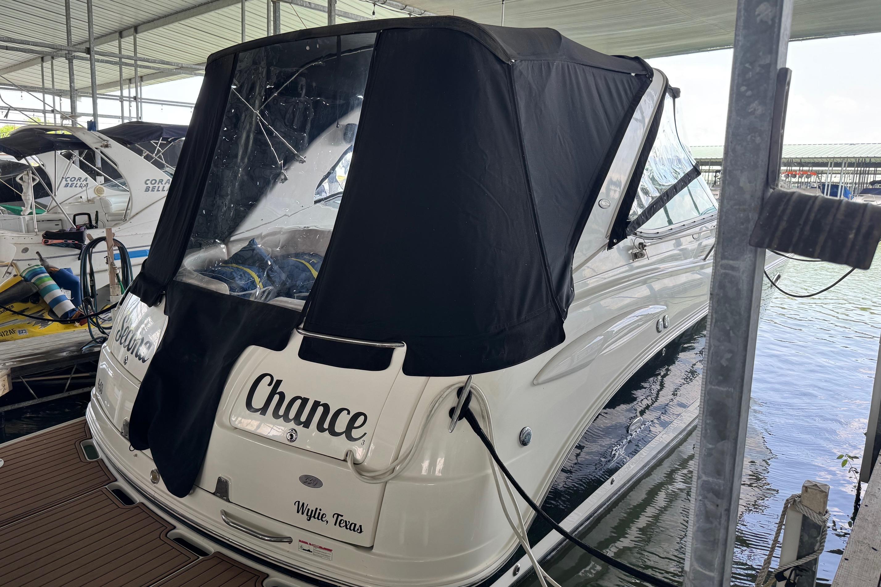 2006 Chaparral 330 Signature boat docked with black cover, named "Chance."