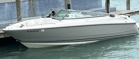 A gray 2009 Monterey 234FS boat is docked on the water.