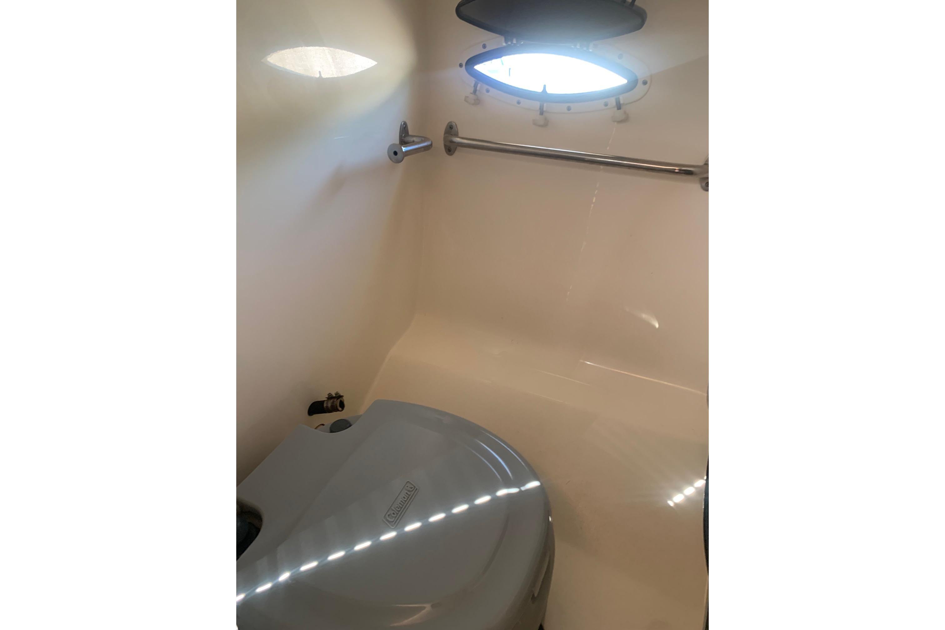 2006 Rinker 282 Captiva Cuddy cabin interior with porthole and compact toilet.