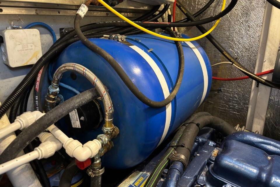 Engine room of 1997 Martland Custom 51ft Aluminium Cutter with blue tank and wiring.
