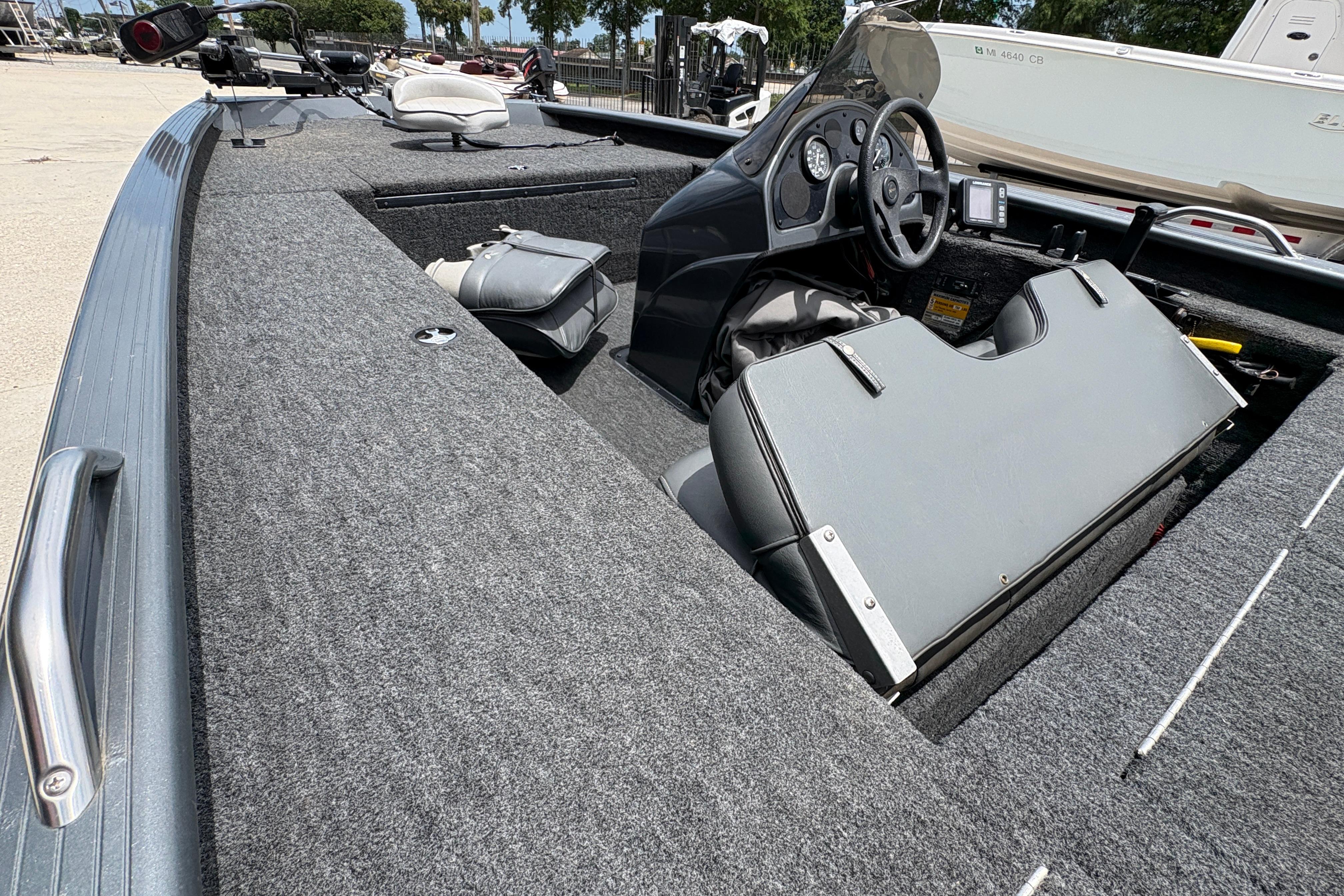 2000 Xpress X18 boat interior with steering wheel and seating, docked outdoors.