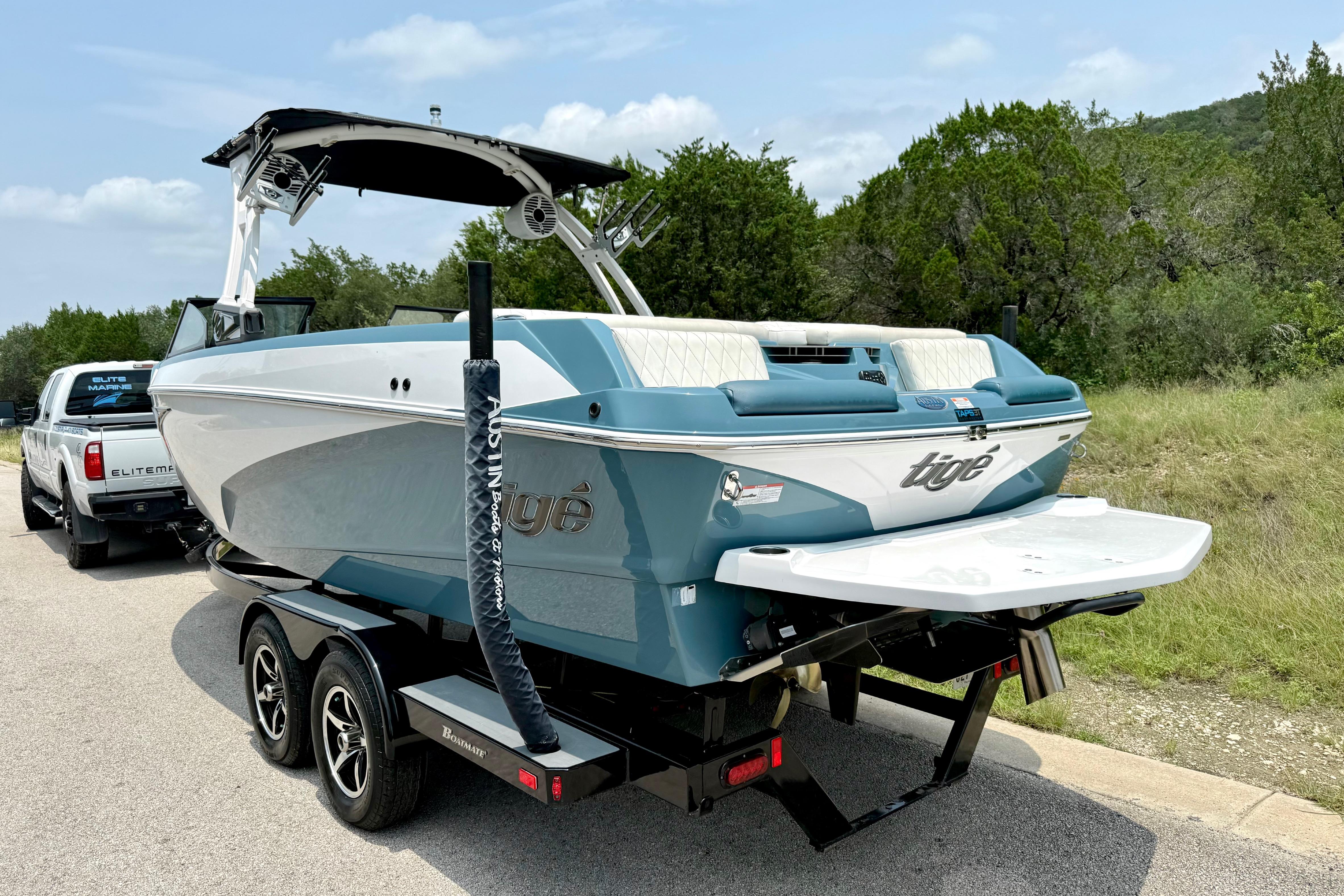 2021 Tige Z3 boat on trailer, parked roadside with lush greenery background.