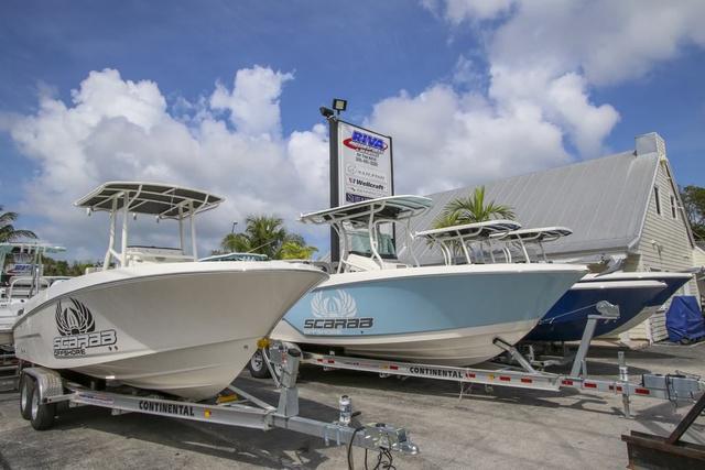 2024 Robalo 206 Cayman boats on trailers at dealership under blue sky.