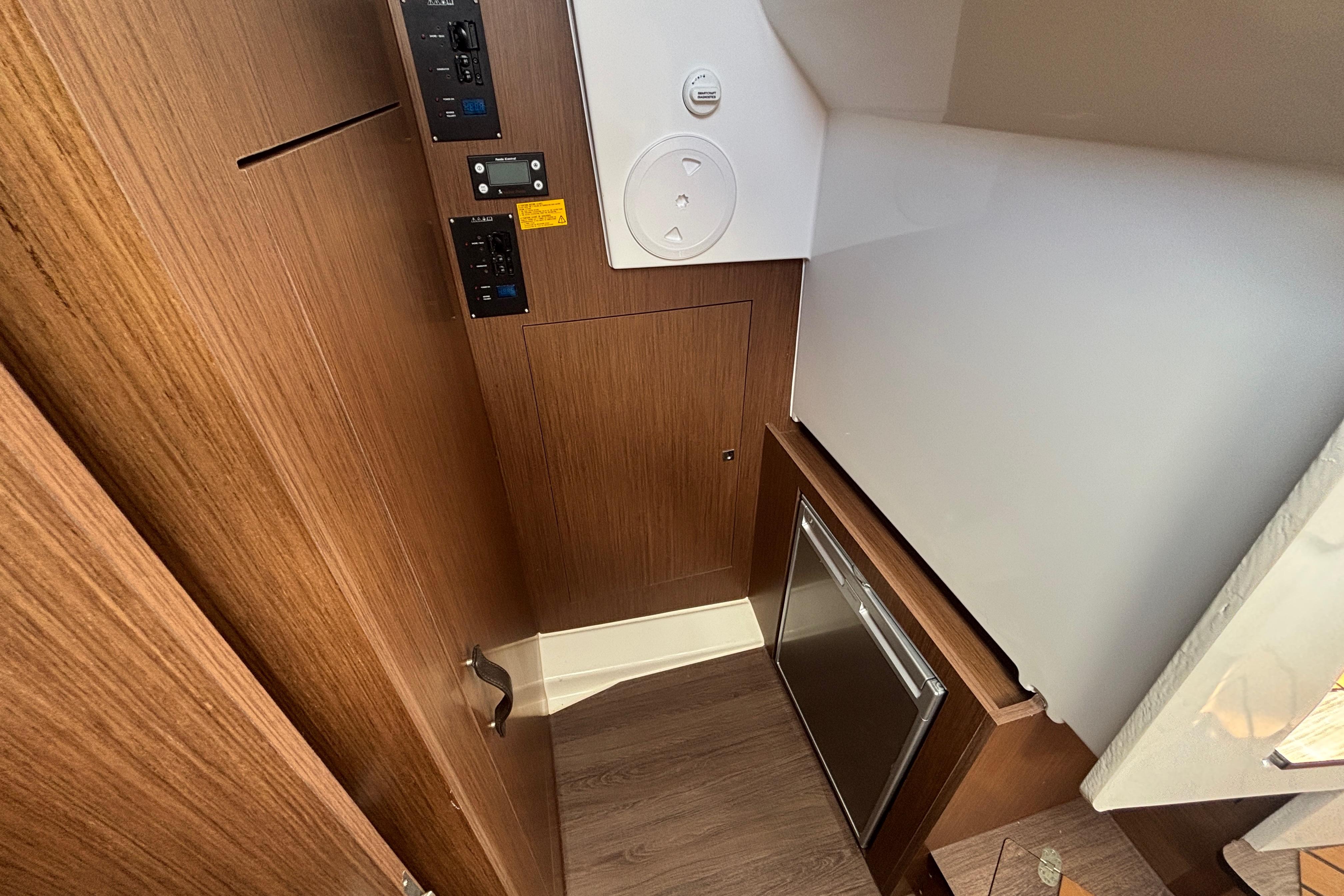 Interior of 2024 Beneteau Antares 11, featuring wood paneling and compact storage.