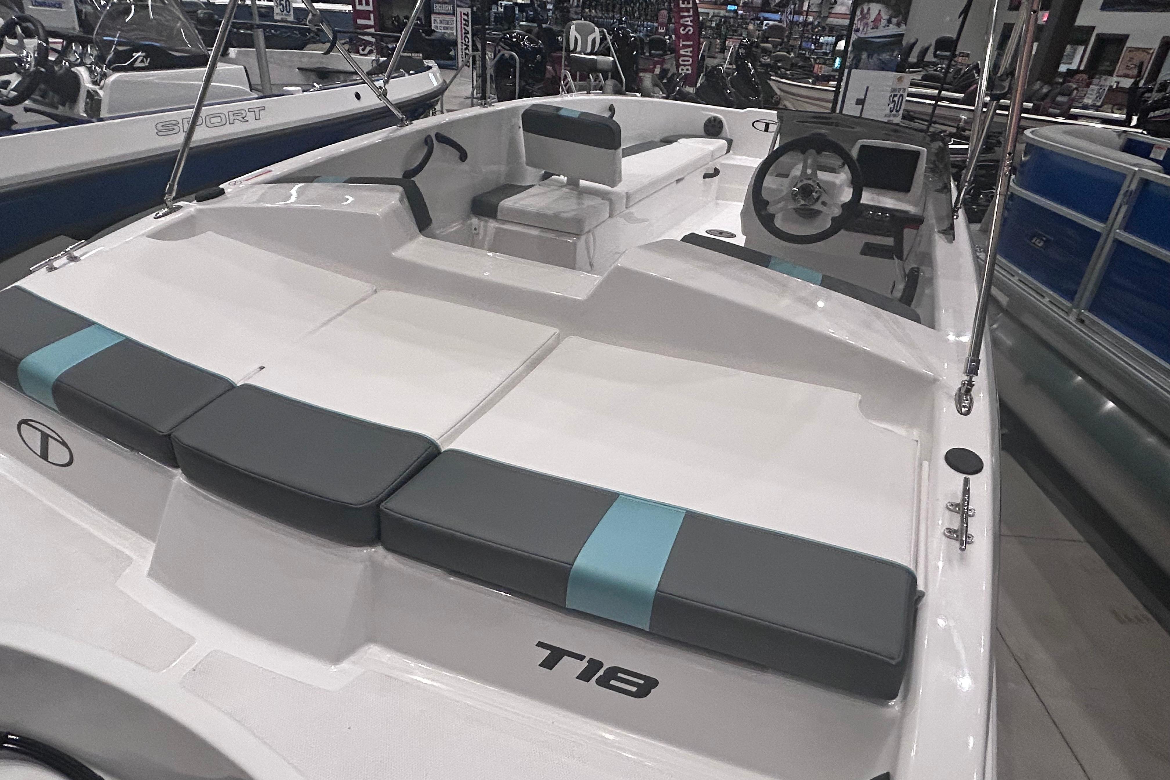 2026 Tahoe T18 boat interior with seating and steering wheel in showroom.